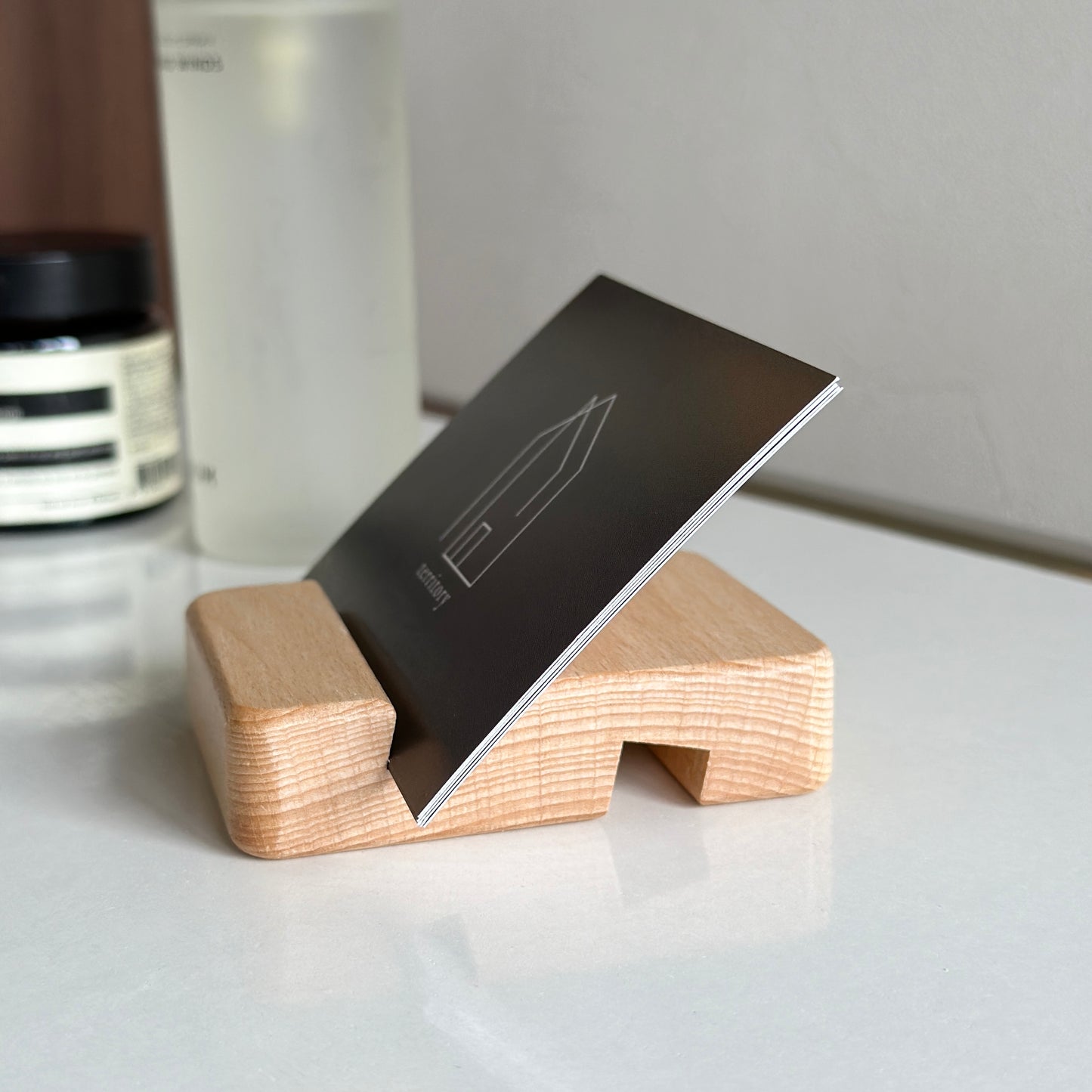 木製のスマホスタンドにショップカードを立てている様子