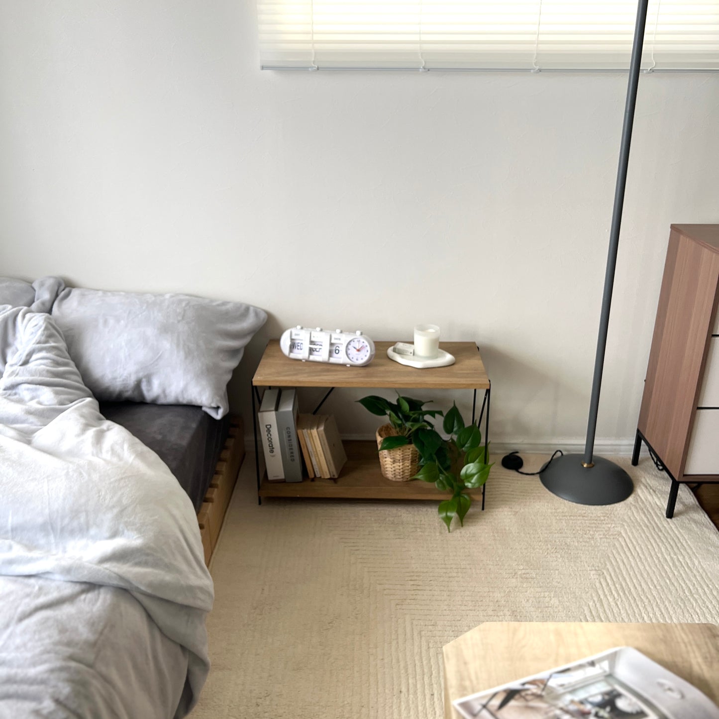 ナチュラルの2段ワイヤーラックをベッド横に置いている様子