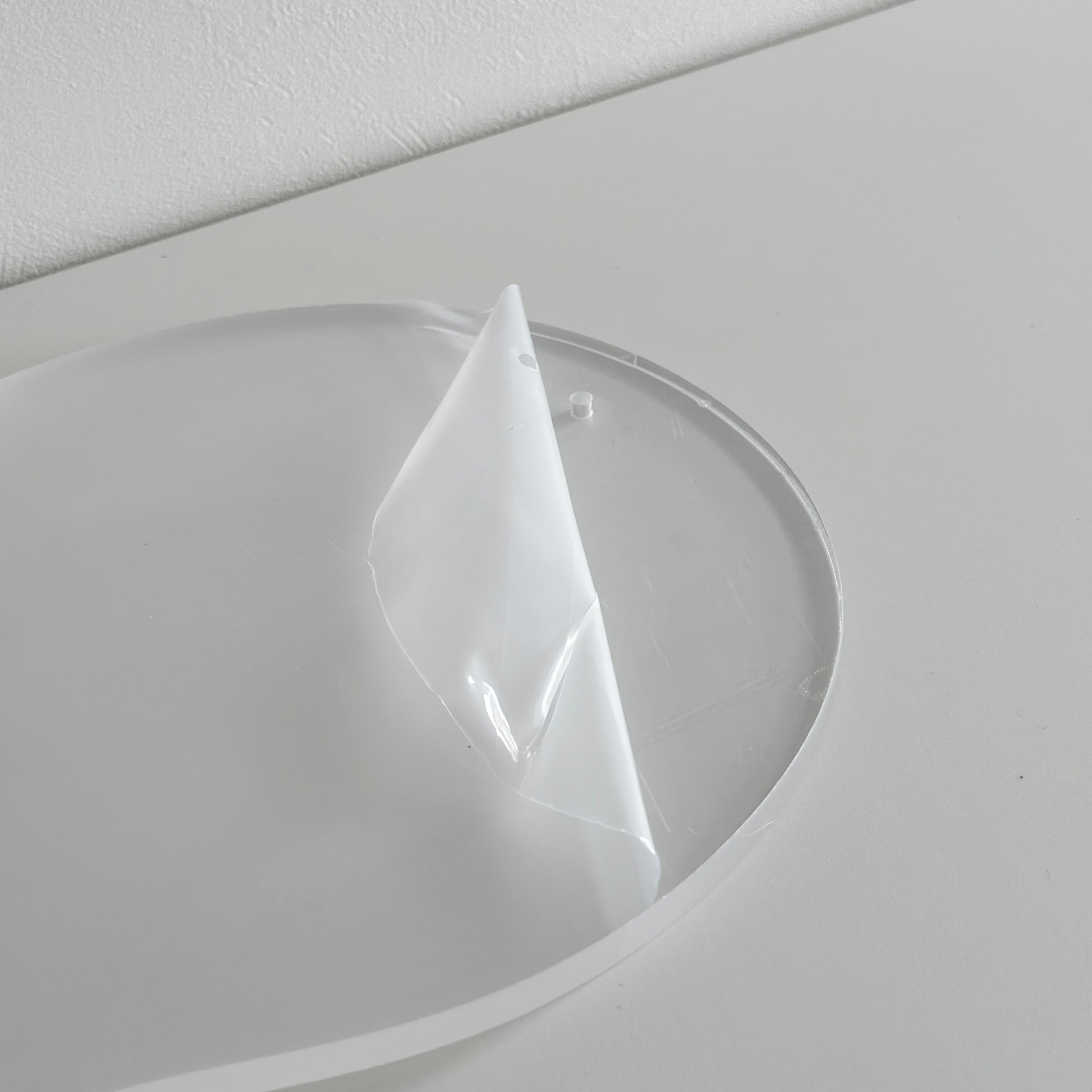 ウッドボールの脚がついたアクリルトレイの保護シールを剥がす様子