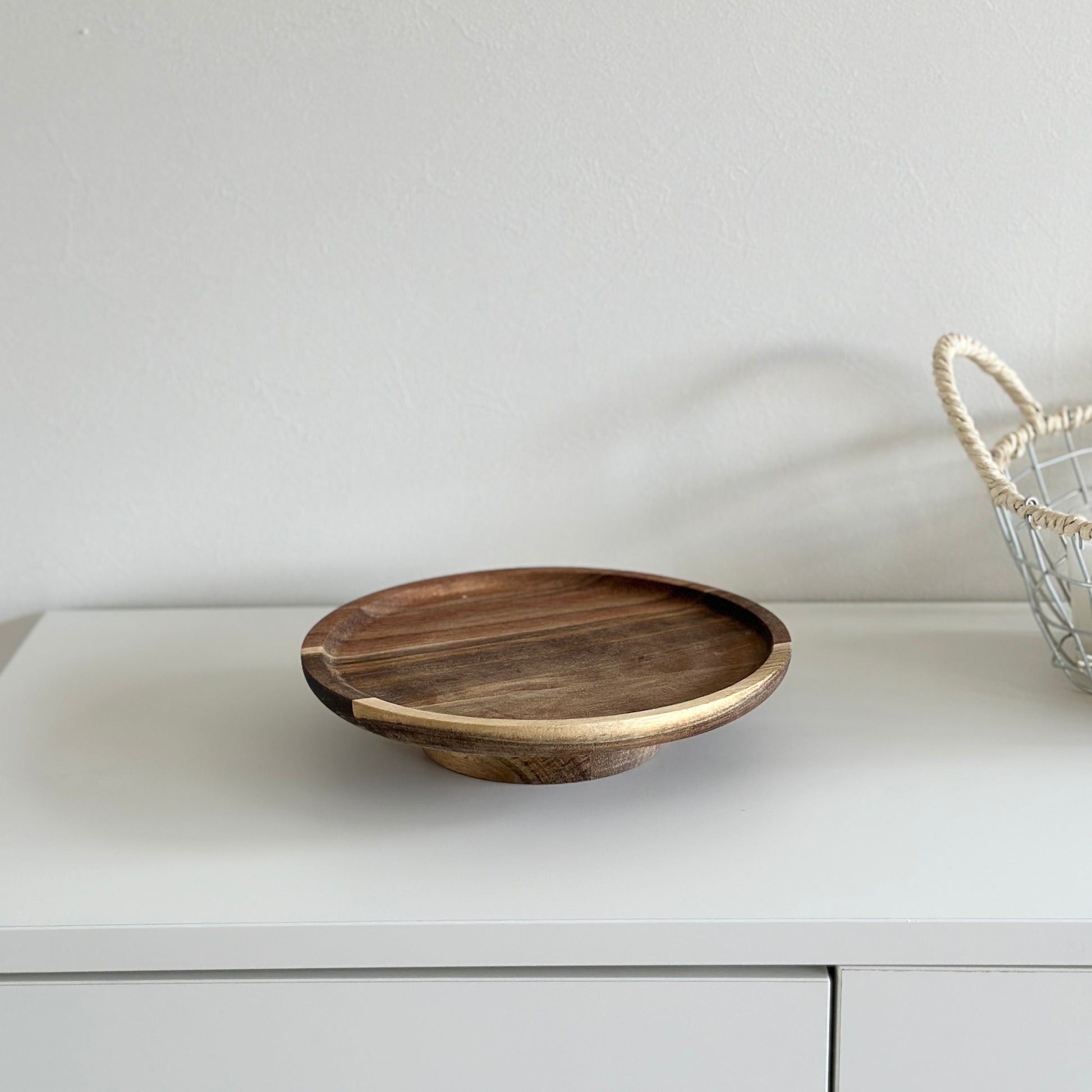 ウッド素材のコンポートを白い棚の上に乗せている様子