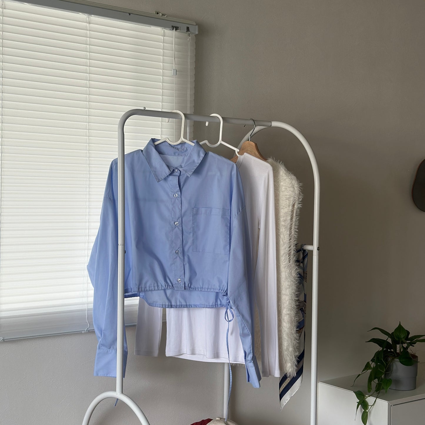3段棚のハンガーラックに洋服が3着かかっている様子