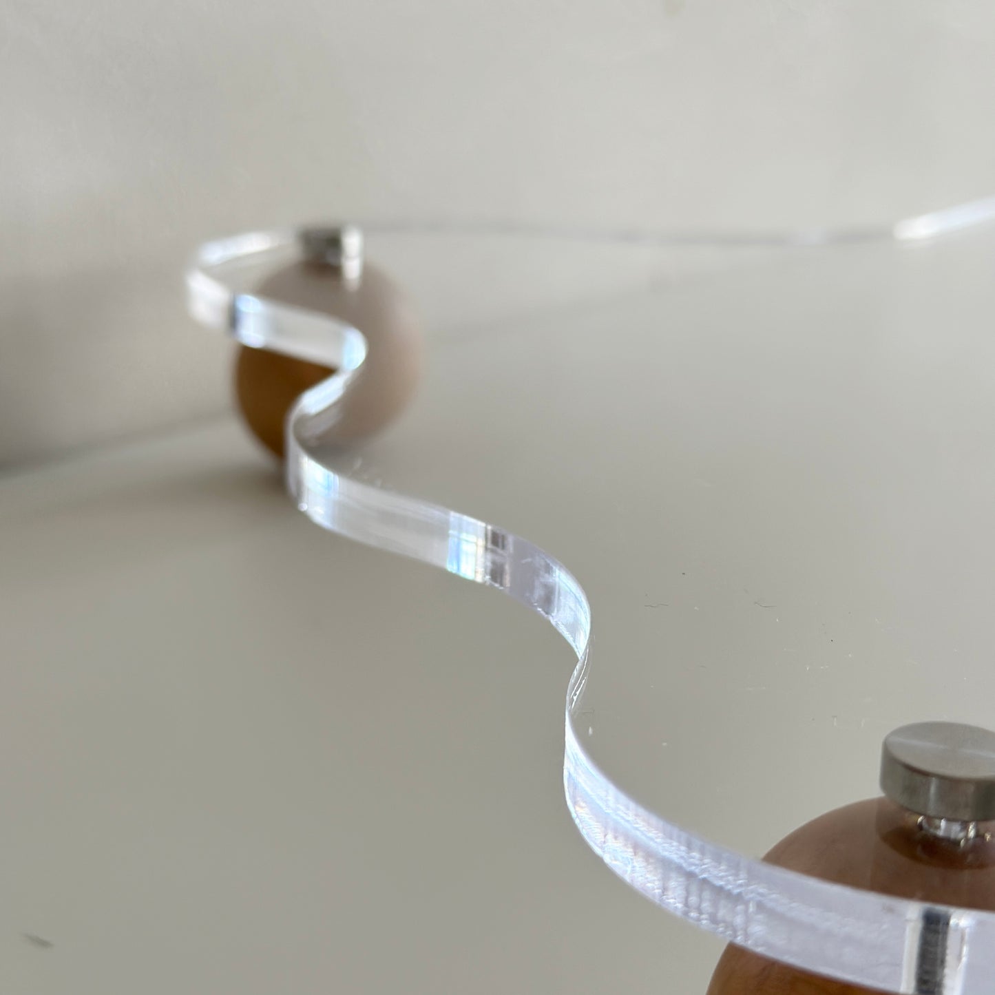 ウッドボールの脚がついたアクリルトレイのふち