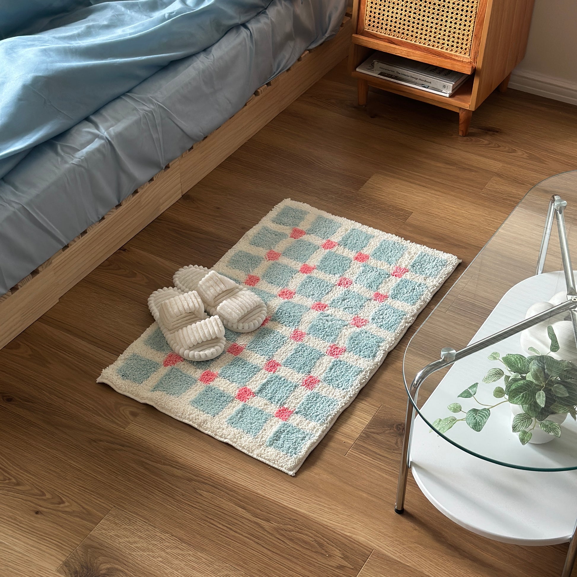 ライトブルーとピンクのスクエア柄のミニラグをベッド横に敷いている様子