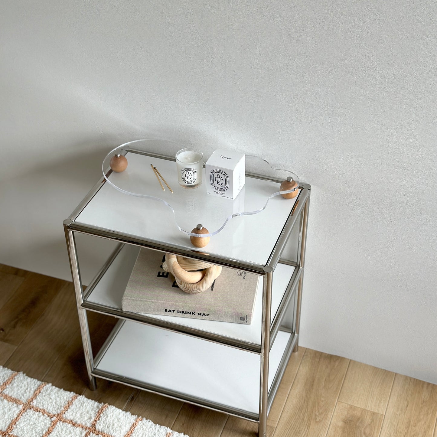 ウッドボールの脚がついたアクリルトレイの上にキャンドルを置いている様子