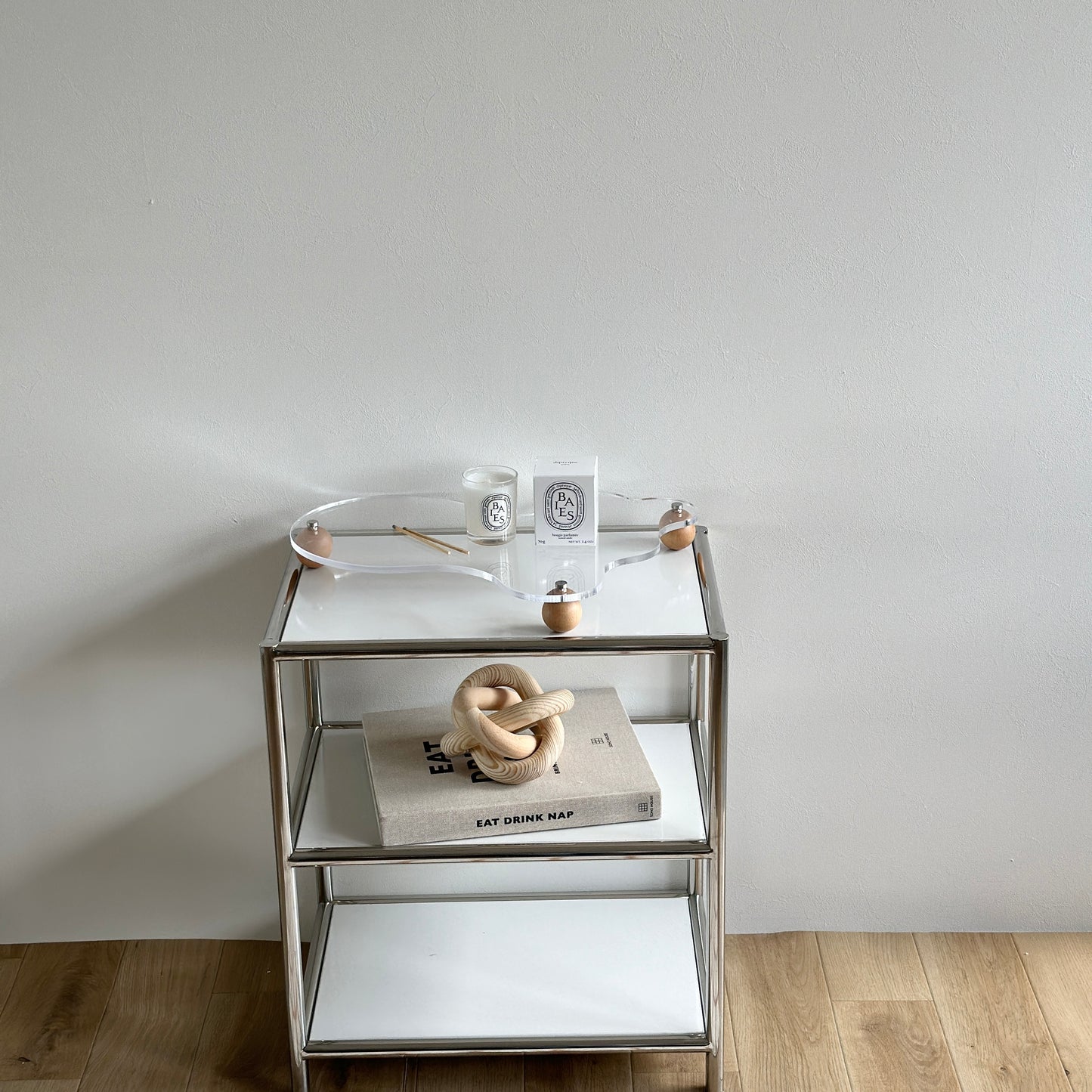 ウッドボールの脚がついたアクリルトレイの上にキャンドルを置いている様子