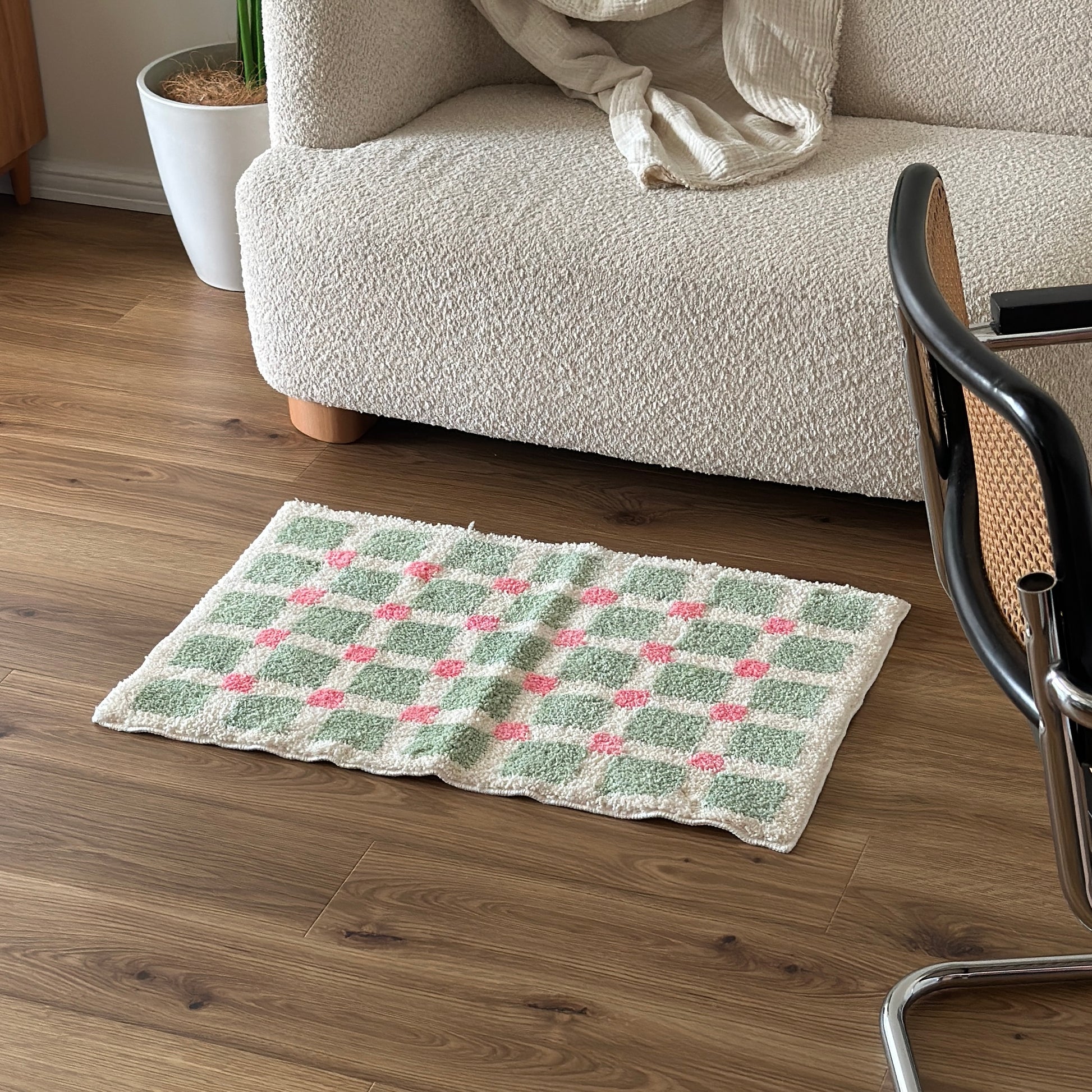 黄緑とピンクのスクエア柄のミニラグをソファ前に敷いている様子