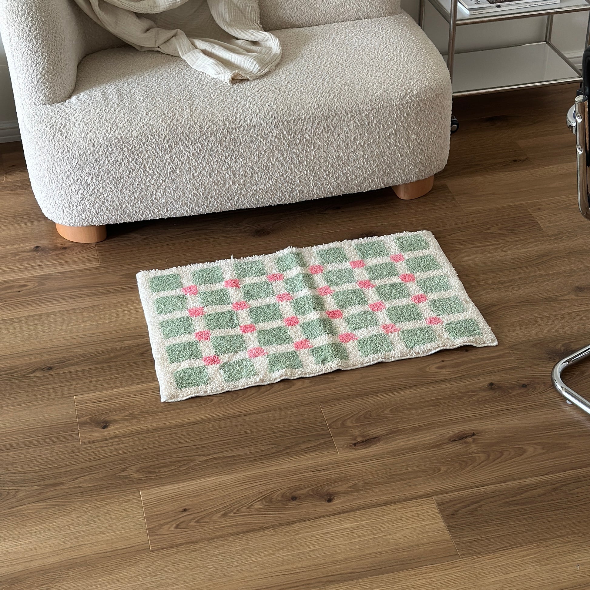 黄緑とピンクのスクエア柄のミニラグをソファ前に敷いている様子