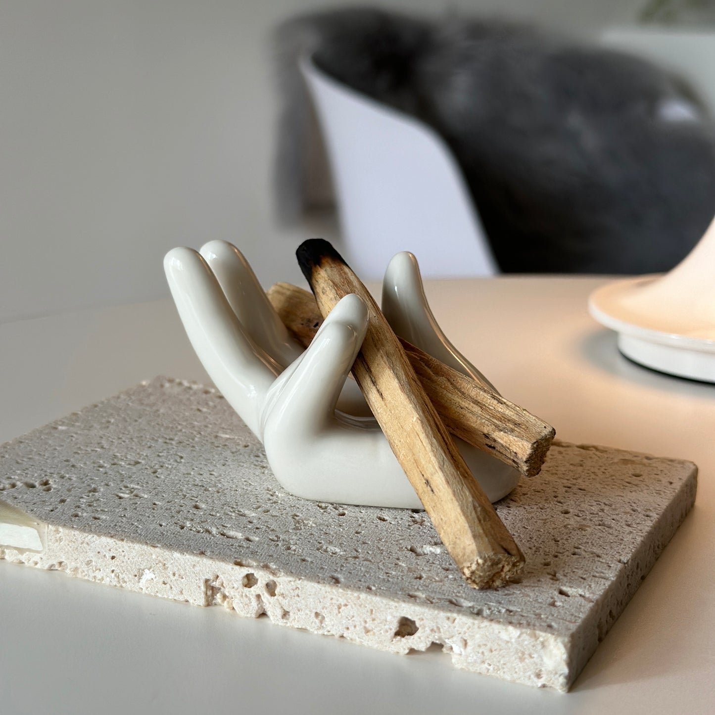 手の形をしたアクセサリーホルダーにパロサントが置かれている様子