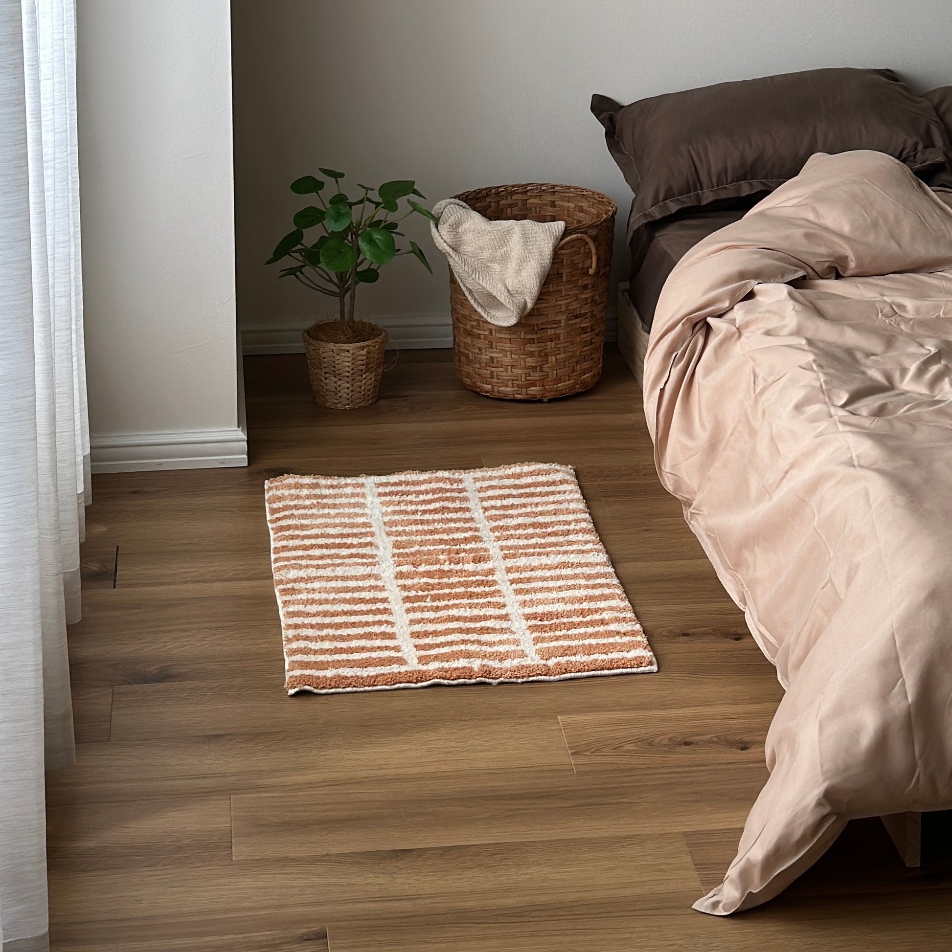 オレンジとホワイトのタイルライン柄のミニラグをベッド横に敷いている様子