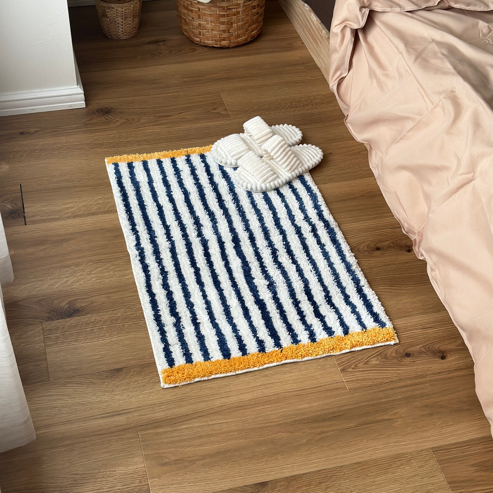 ブルーのボーダーとイエローの縁取りのミニラグを部屋で使っている様子