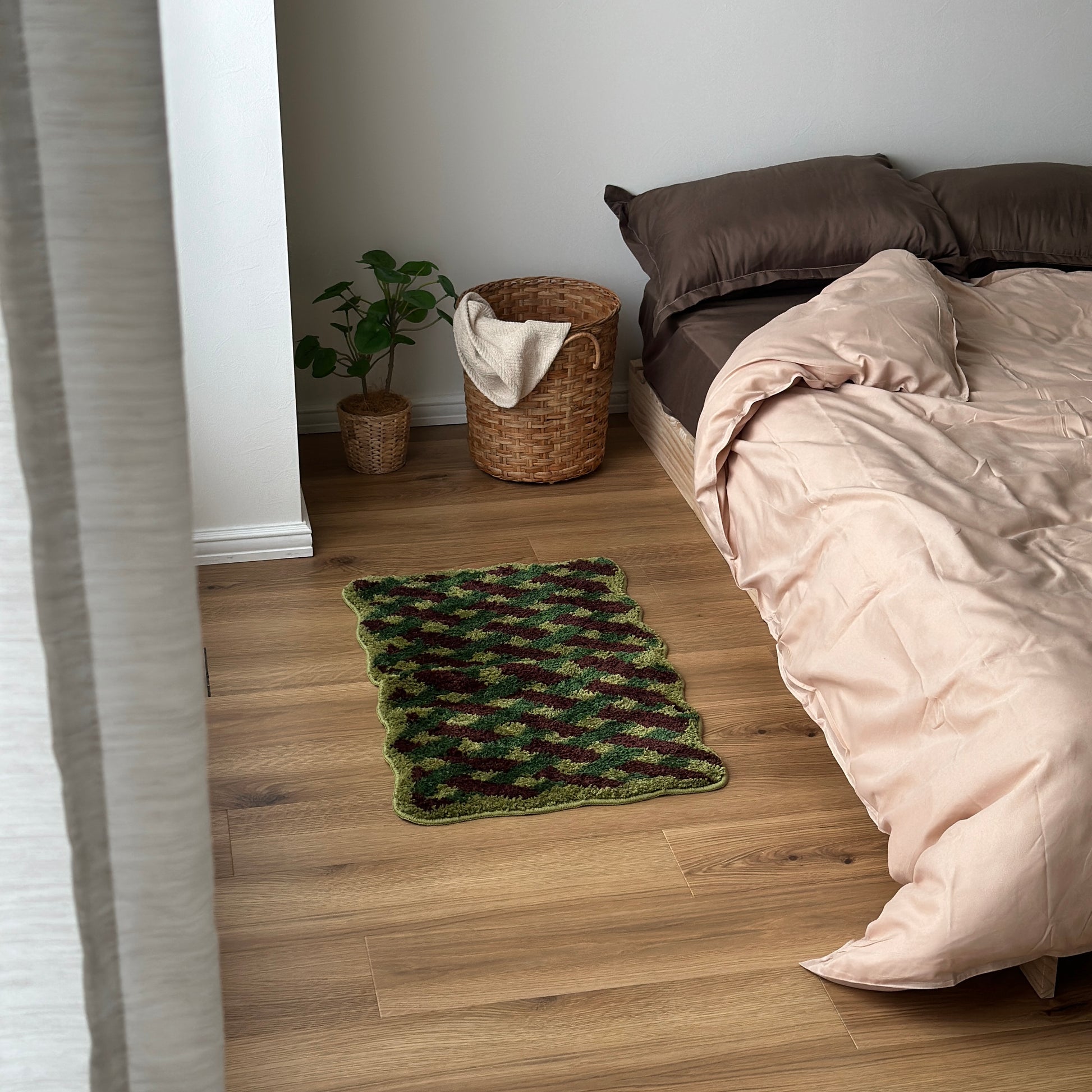 グリーンのウェーブクロス柄のミニラグをベッド横に敷いている様子