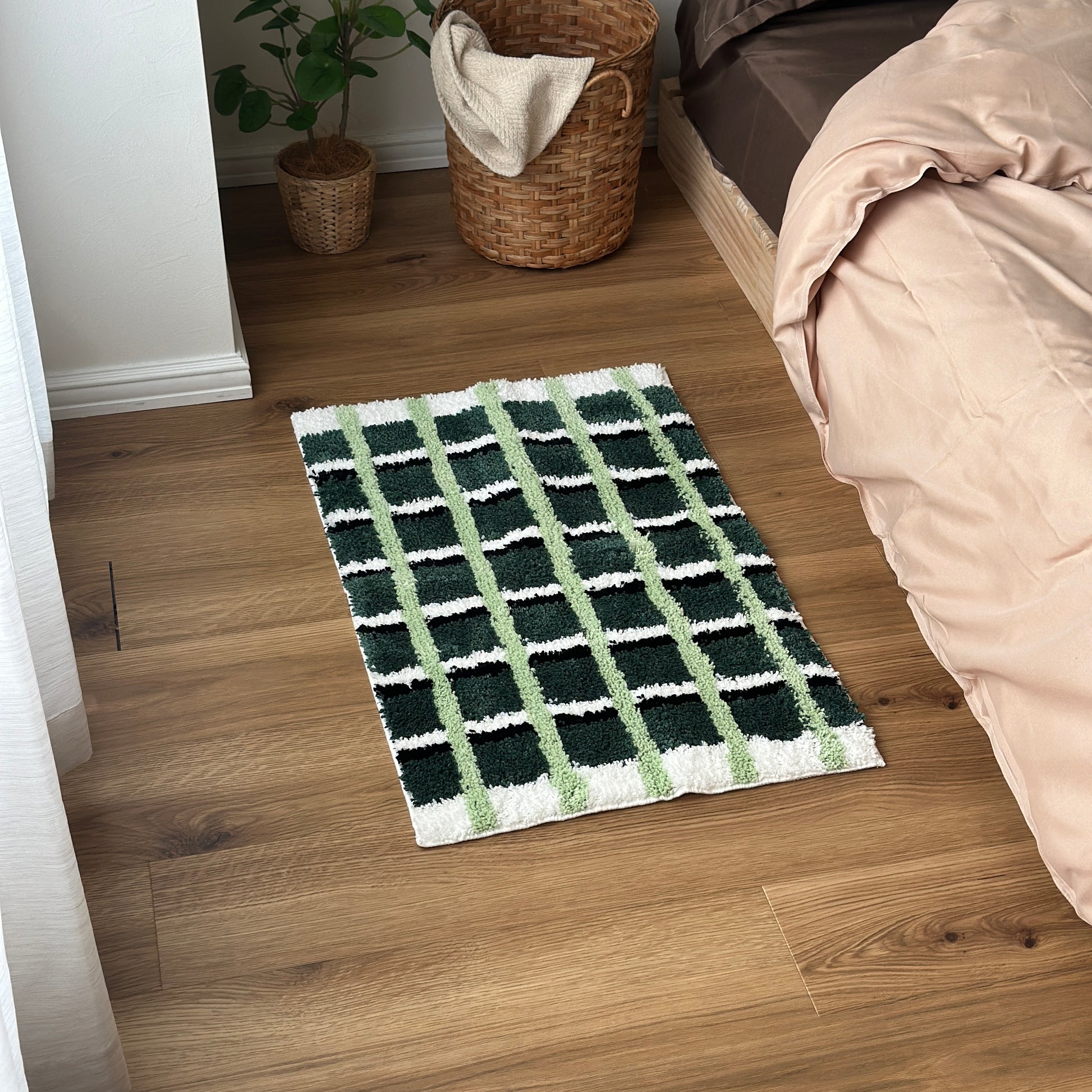 黄緑と深緑とブラックの3色が入ったチェック柄のミニラグをベッド横に敷いている様子