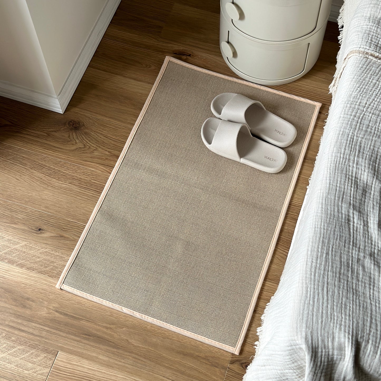 リネン素材のラグマットをベッドサイドに置いている様子