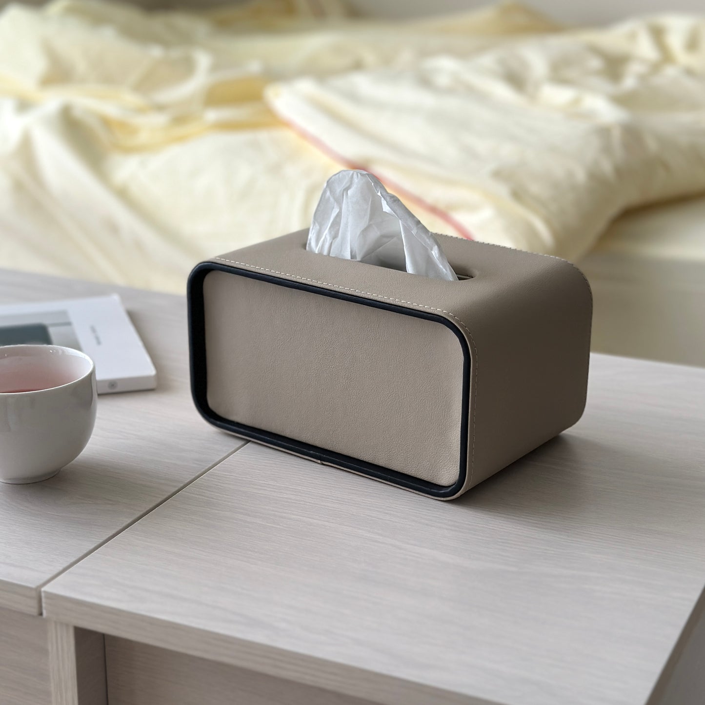 ミルクティー色のレザー調の見た目が特徴のティッシュケースがテーブルの上に置かれている