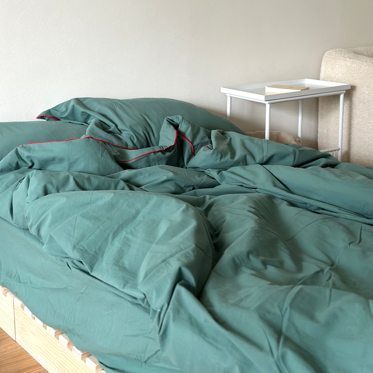 グリーンのベッドカバーが掛かったベッドがある部屋