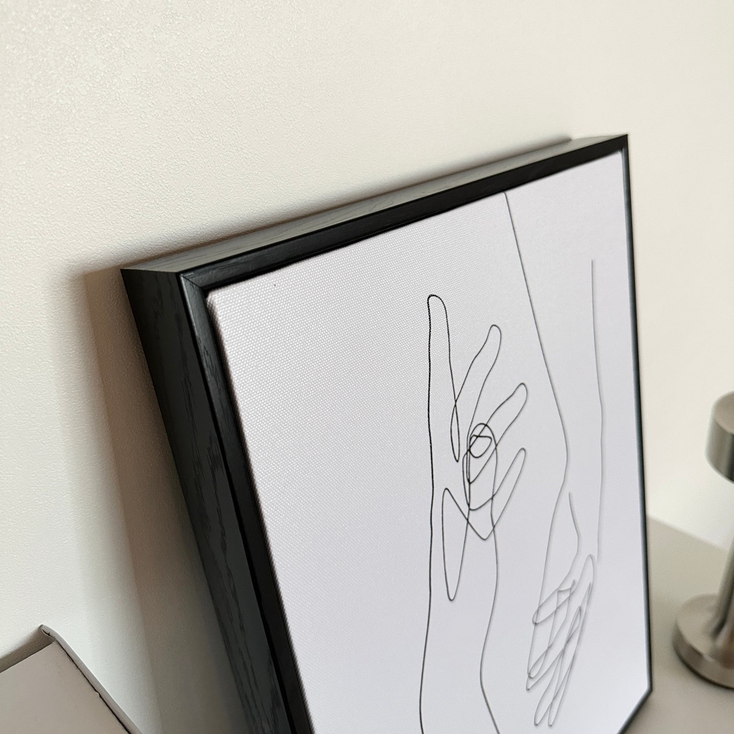 2つの手が描かれたアートの額縁