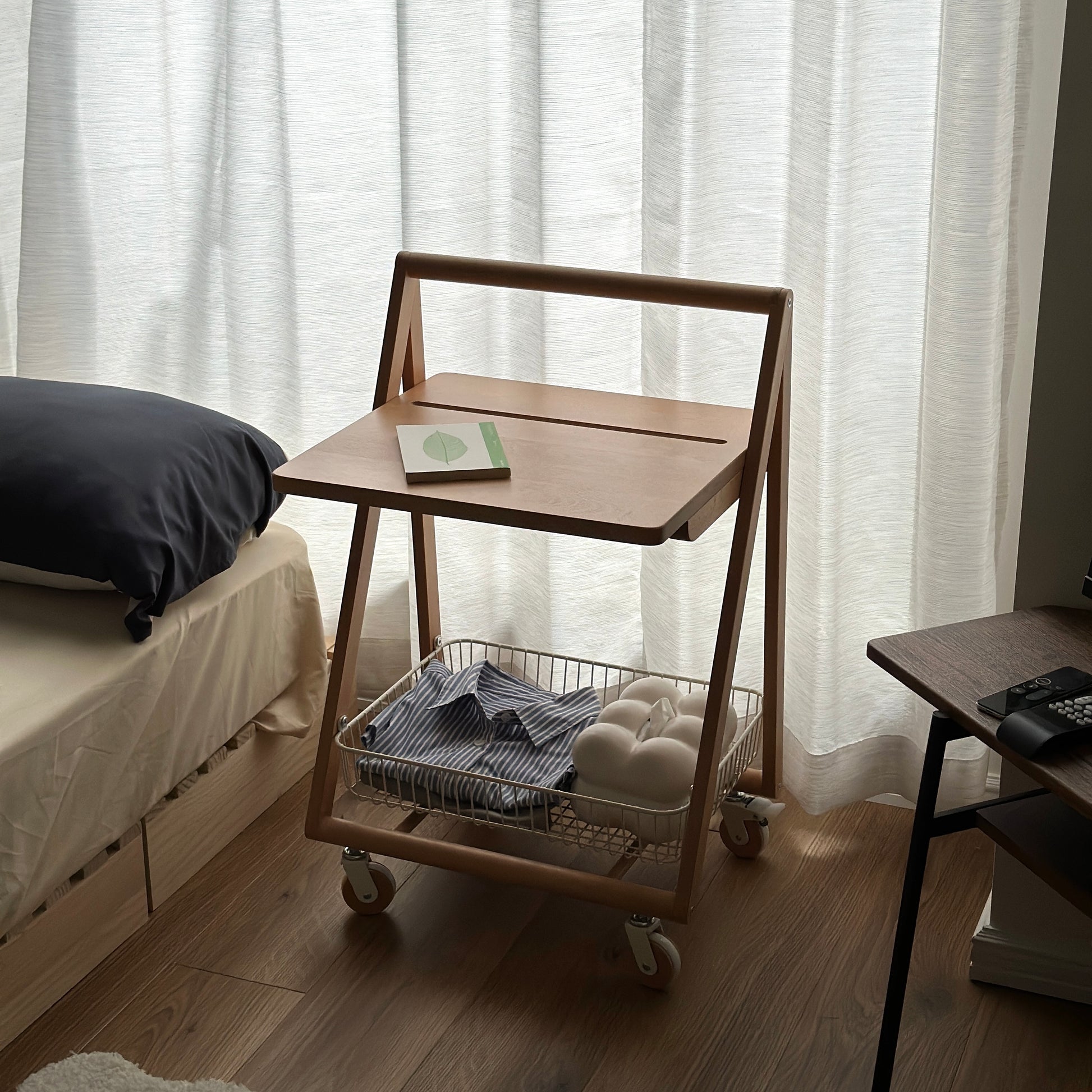 ナチュラルウッドのキャスター付きサイドテーブルをベッドサイドで使っている様子
