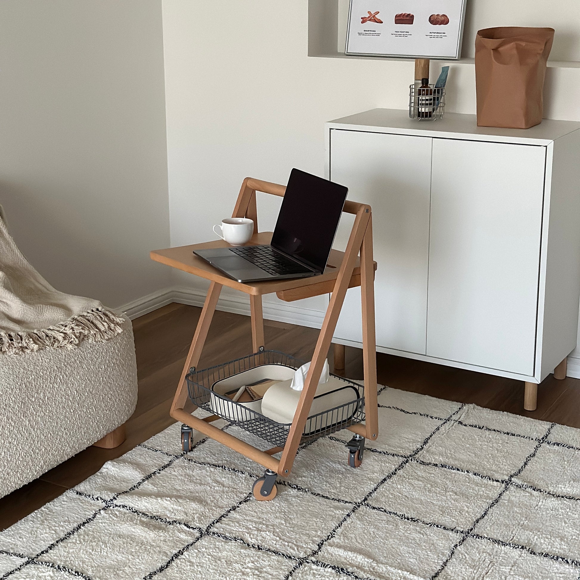 ナチュラルウッドのキャスター付きサイドテーブルの上にティーカップとパソコンが置かれてある