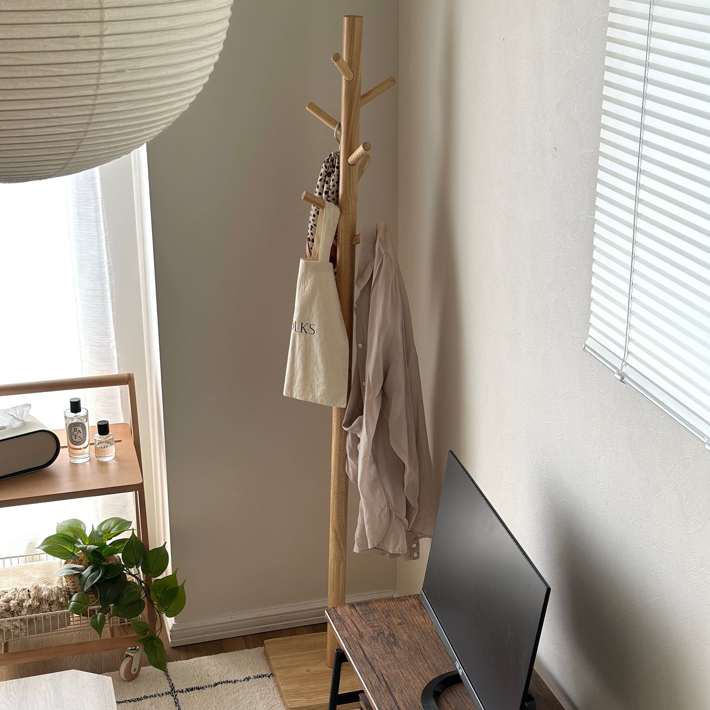 木製のポールハンガーラックを部屋の隅で使っている様子