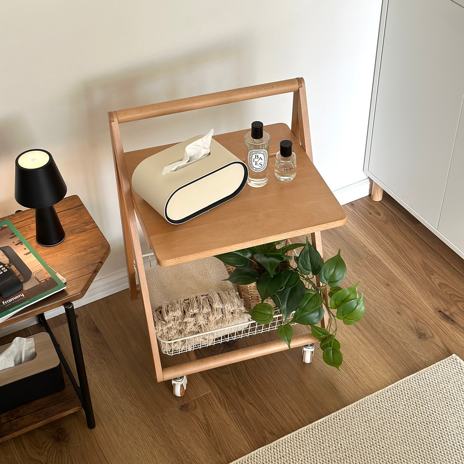 ナチュラルウッドのキャスター付きサイドテーブルの上にティッシュケースや香水、植物が置かれてある様子