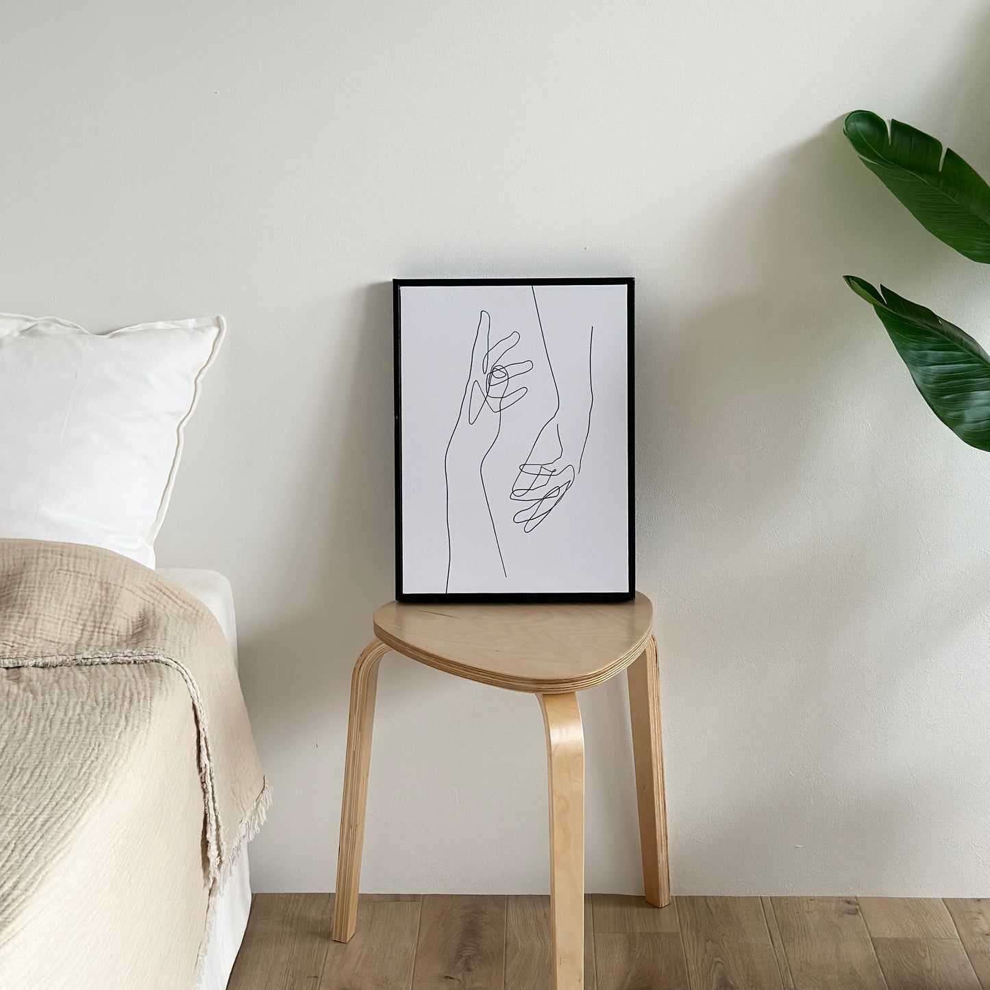 スツールの上に2つの手が描かれたアートが置かれている