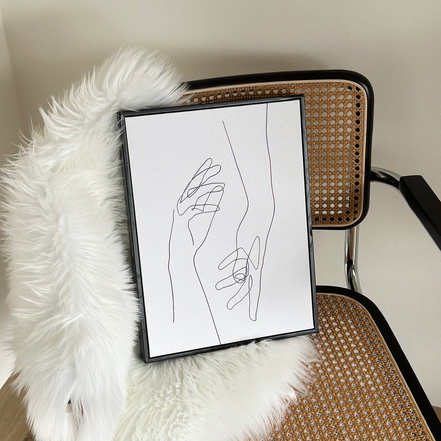 2つの手が描かれたアートが椅子の上に置かれている