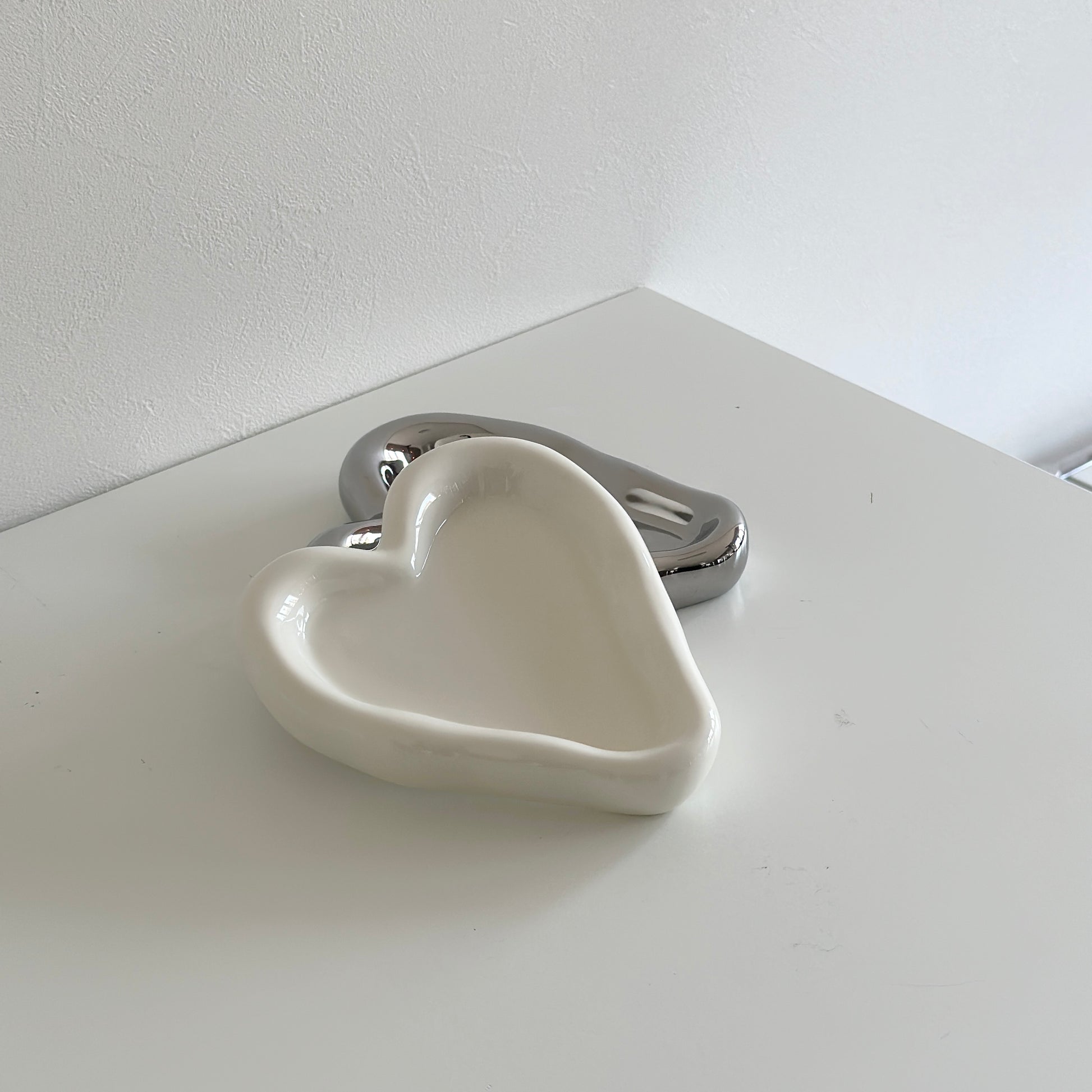 縁があるホワイトとシルバーのハート型のプレート