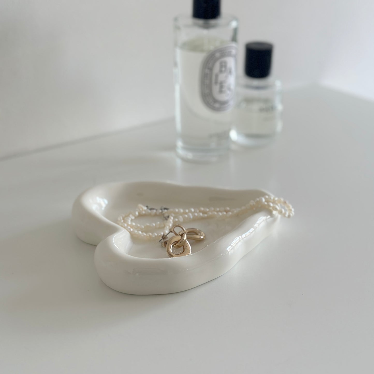 縁があるホワイトのハート型のプレートにアクセサリーが乗っている様子