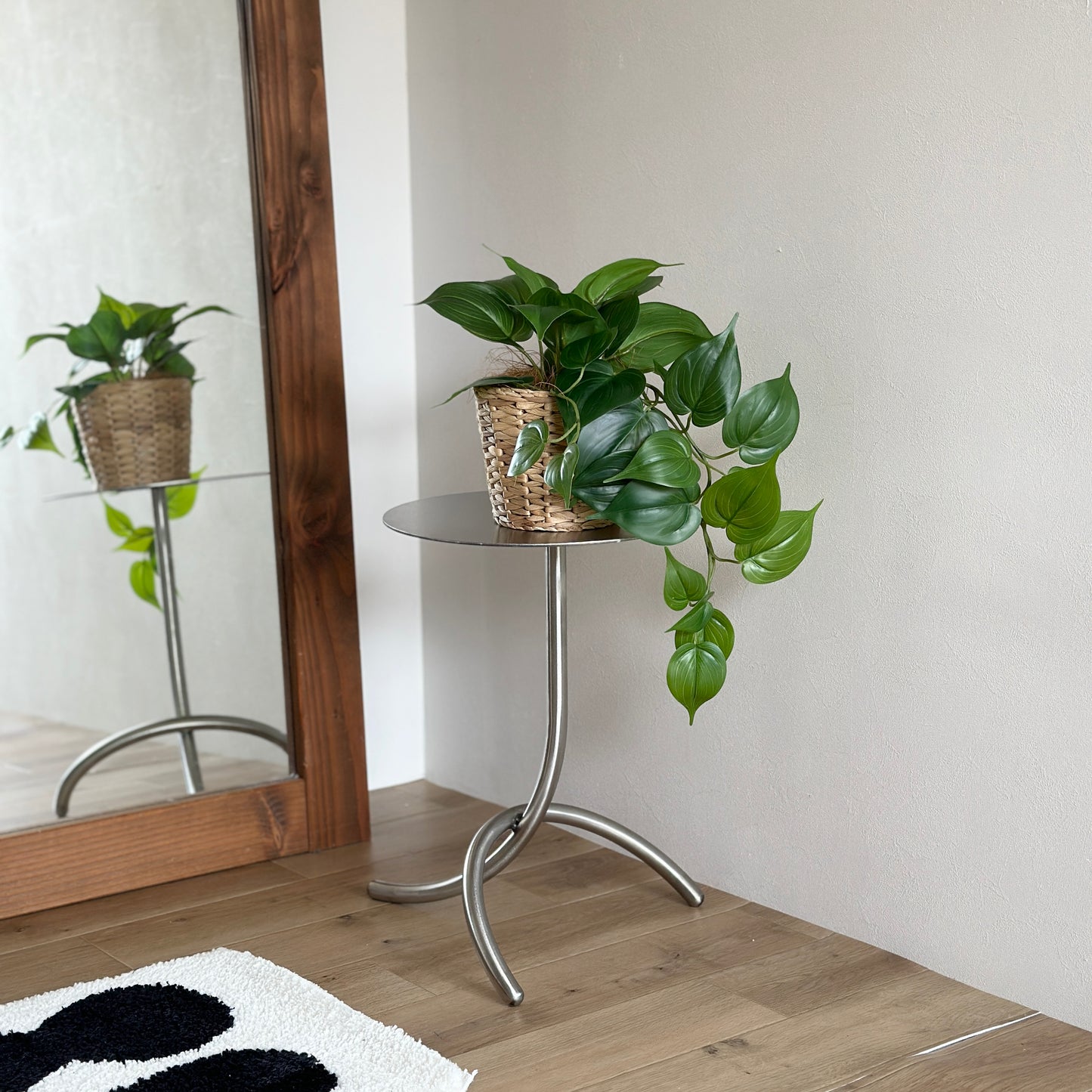 ユニークな脚のシルバーのミニテーブルの上に植物がのっている様子