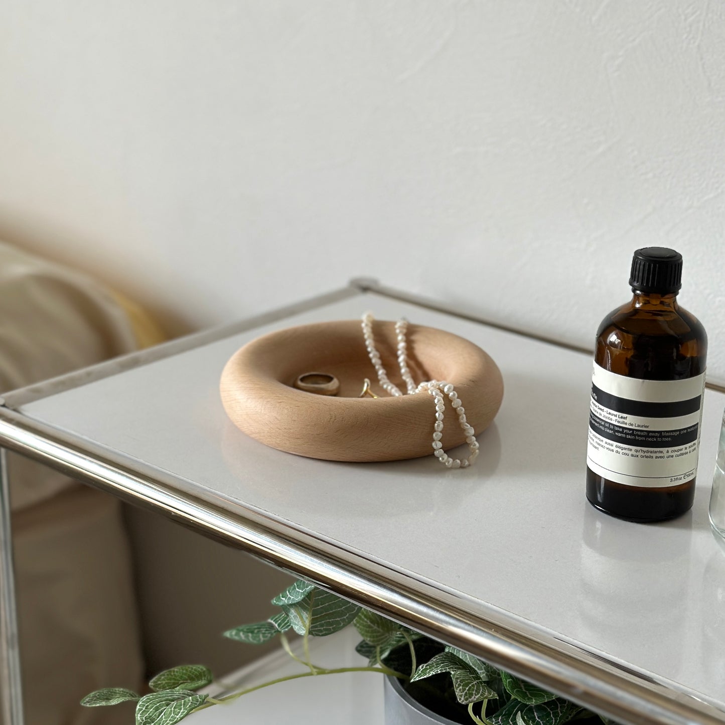 フチがぽってりとした木のプレートの上にアクセサリーが置かれてある。