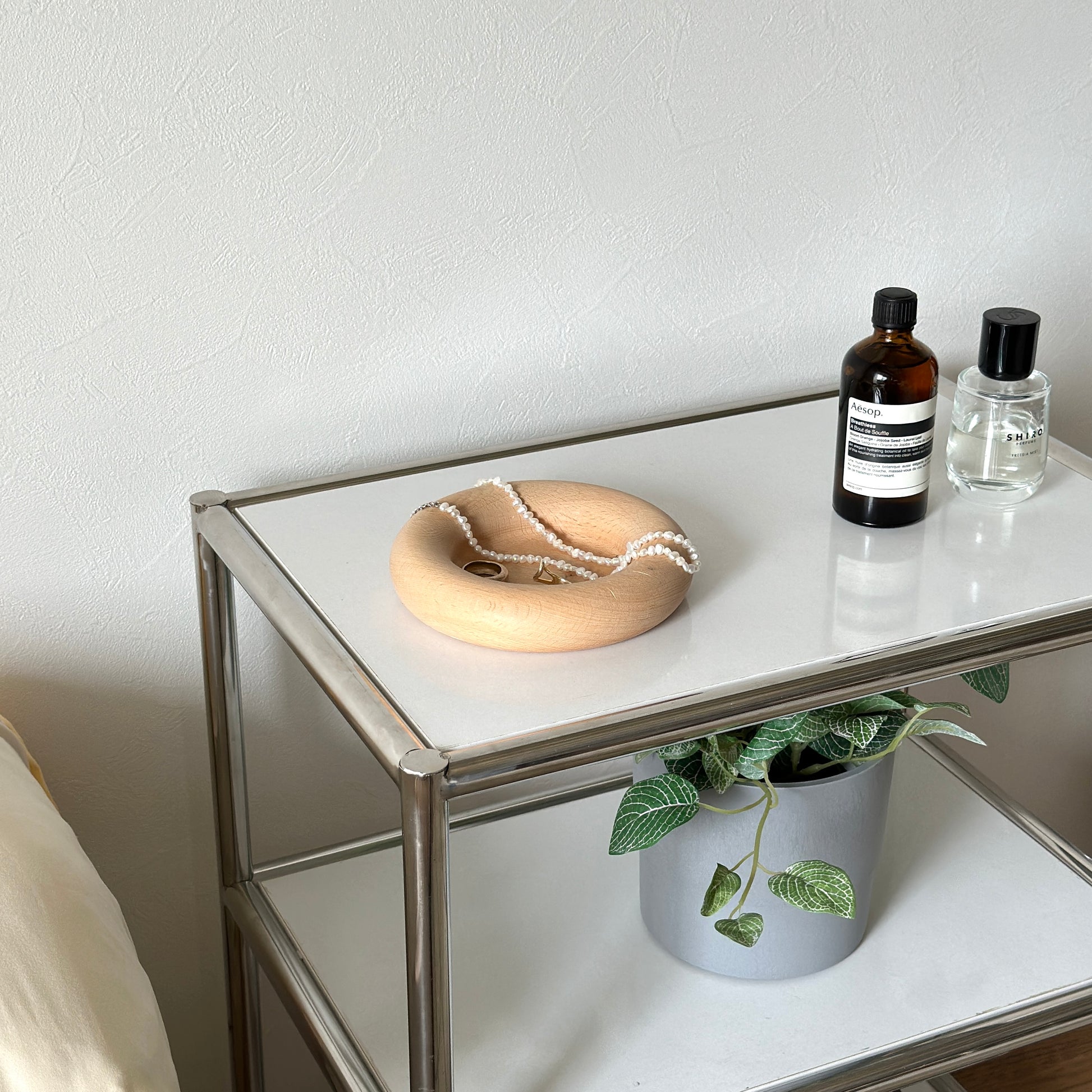 フチがぽってりとした木のプレートの上にアクセサリーが置かれてある。