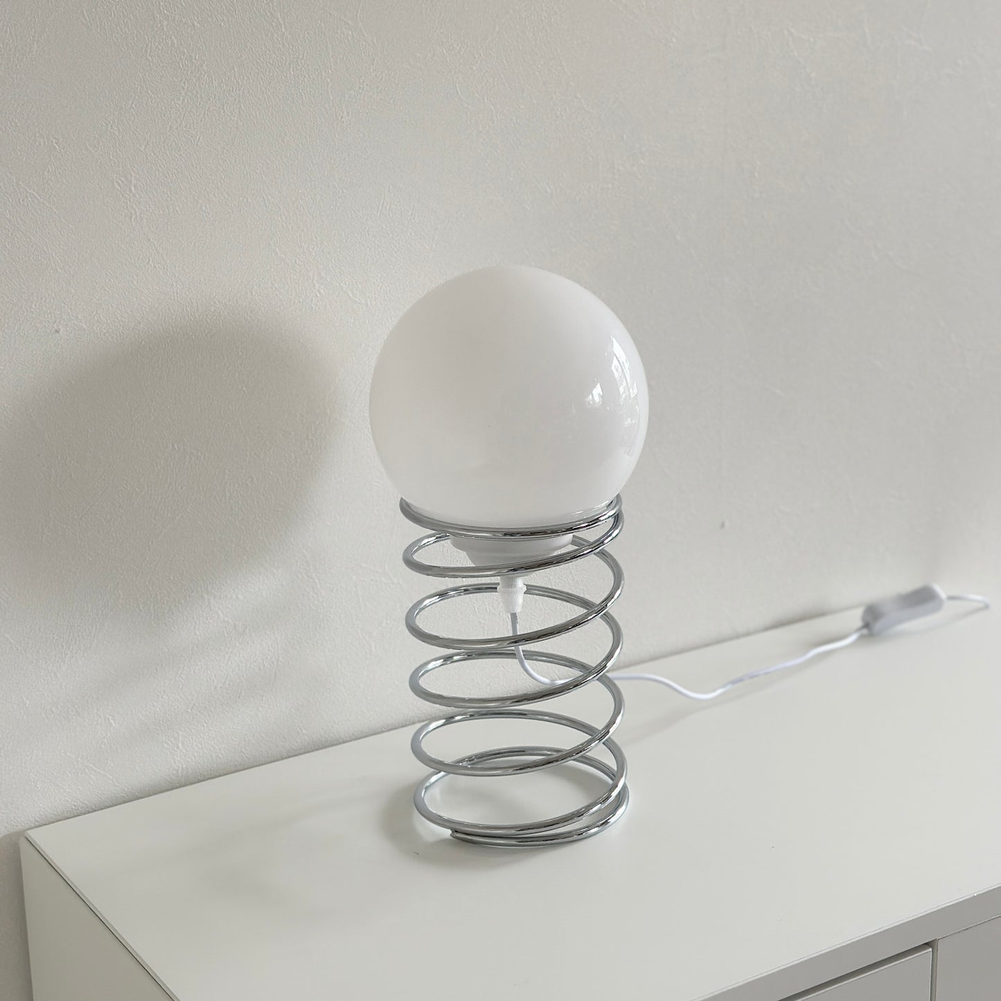 土台がバネのようなシルエットのテーブルライト