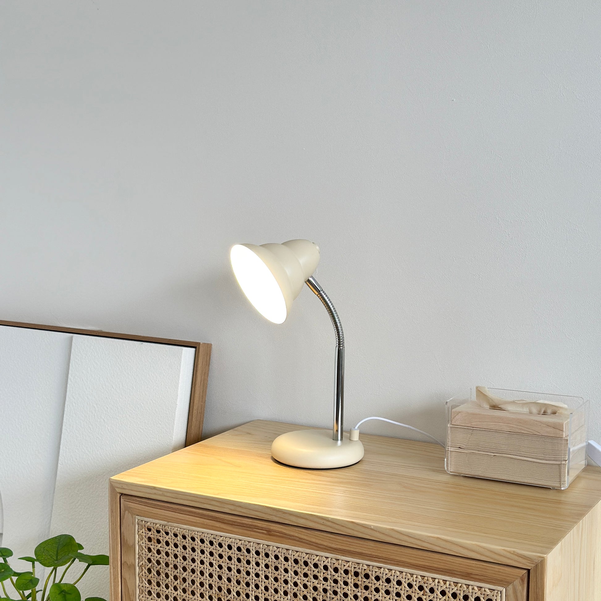 くすんだイエローカラーのデスクライトがサイドボードの上にティッシュケースと置かれている