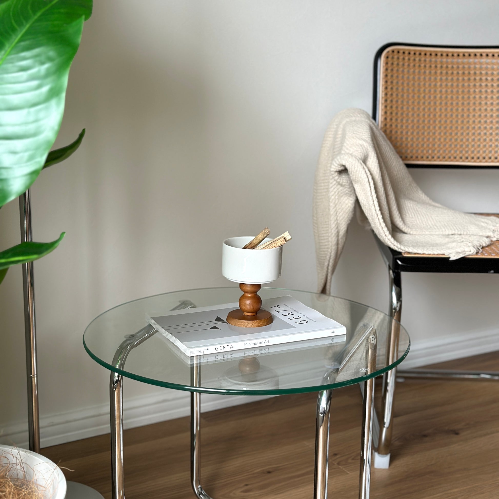 透明なガラステーブルの上に陶器の器にウッド脚が付いたボウルが置かれてある。