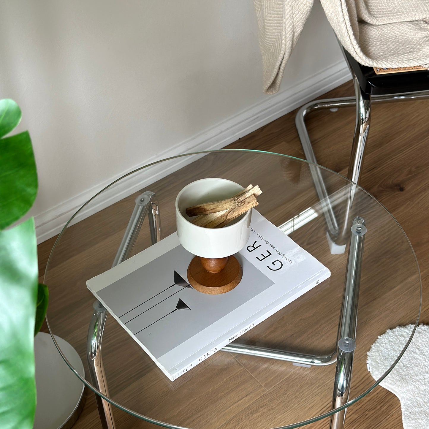 透明なガラステーブルの上に陶器の器にウッド脚が付いたボウルが置かれてある。