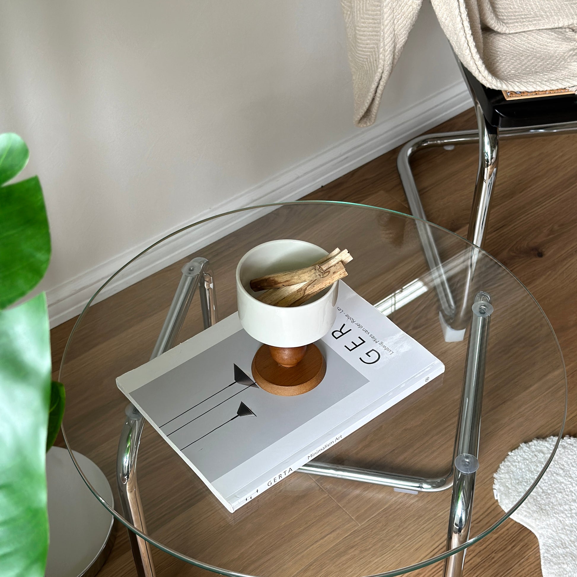 透明なガラステーブルの上に陶器の器にウッド脚が付いたボウルが置かれてある。