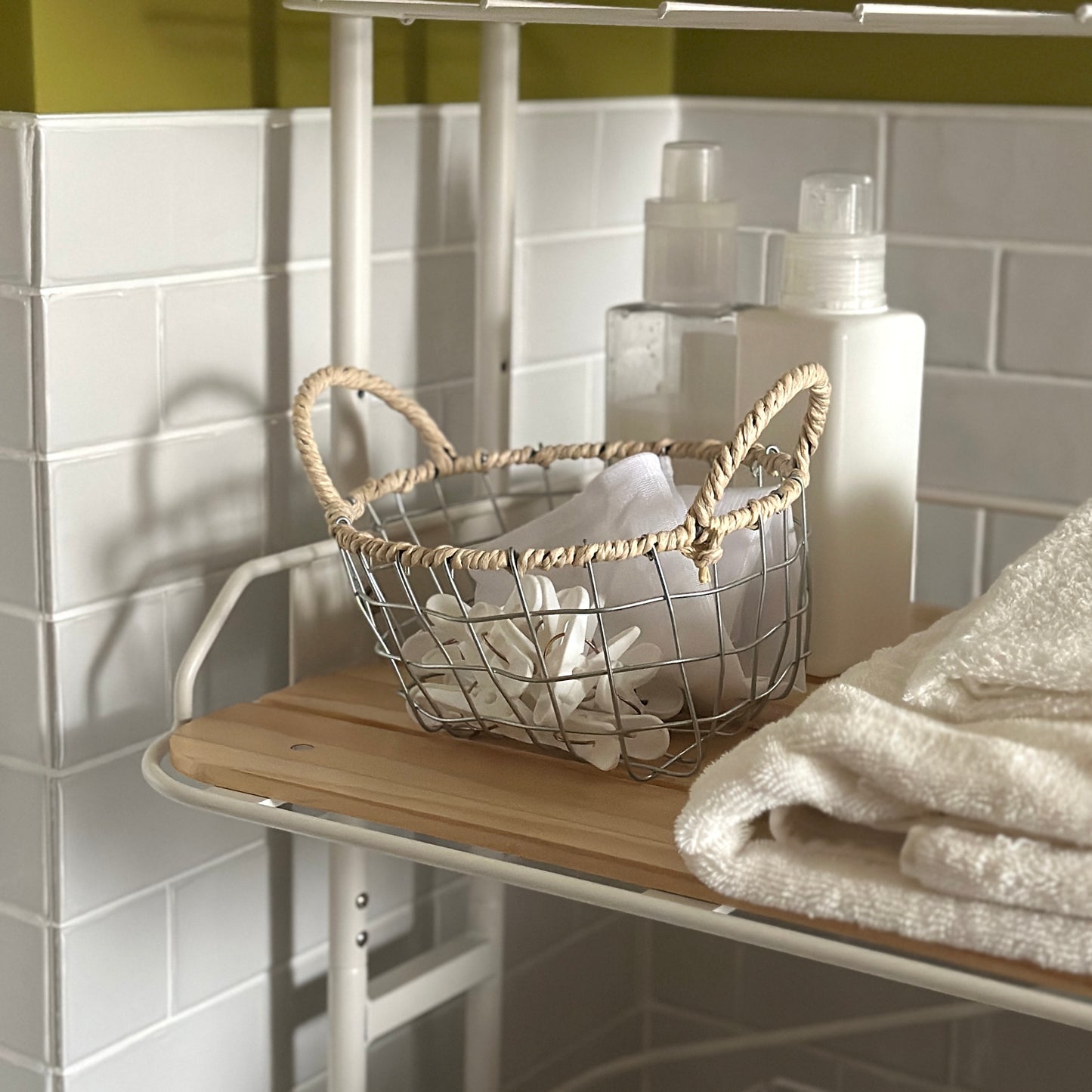 ワイヤーで作られた歪んだ形をしたバスケットの中に洗濯バサミと洗濯ネットが入ってある。