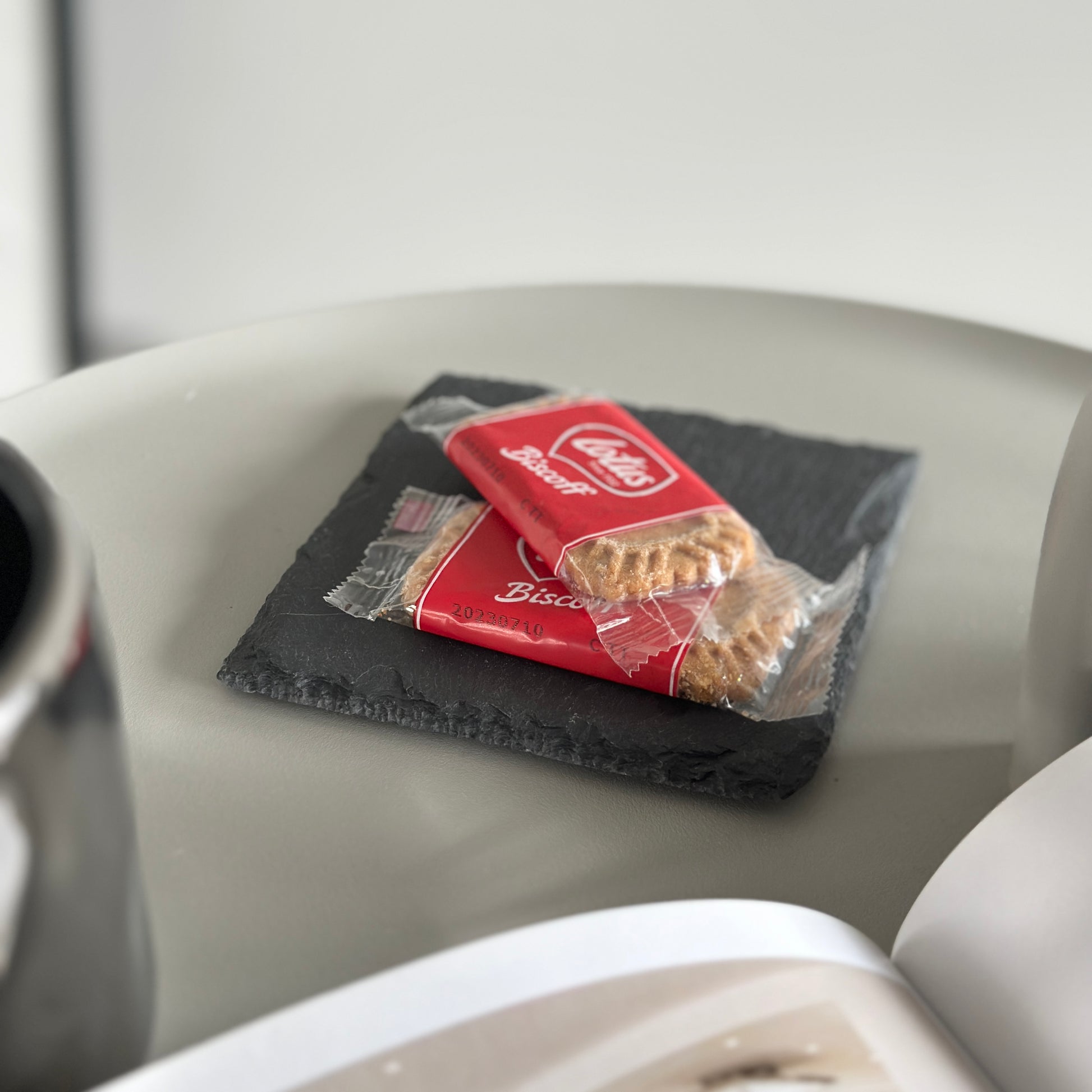 丸いテーブルの上にある黒い石のプレートにお菓子が乗っている