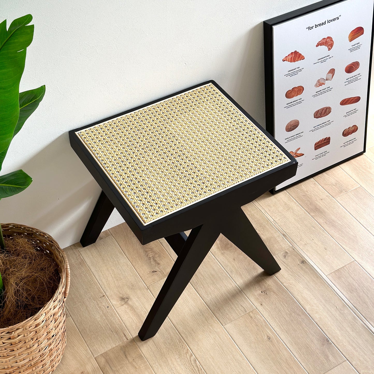 ラタン調のスツールが壁前、ポスター横に置いてある