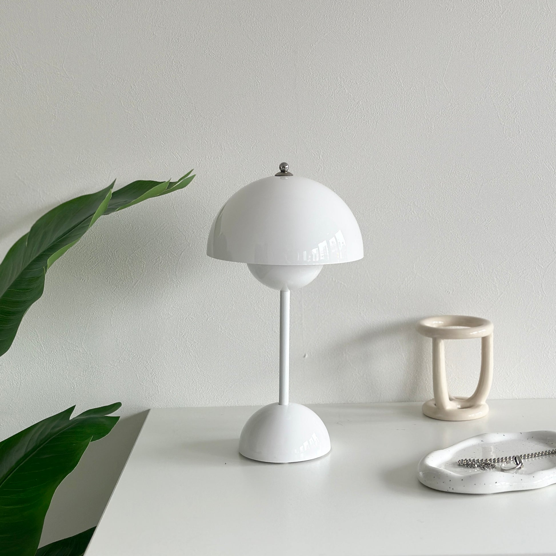 棚の上に乗せられた半球型のシルエットが特徴的なホワイトのテーブルライト