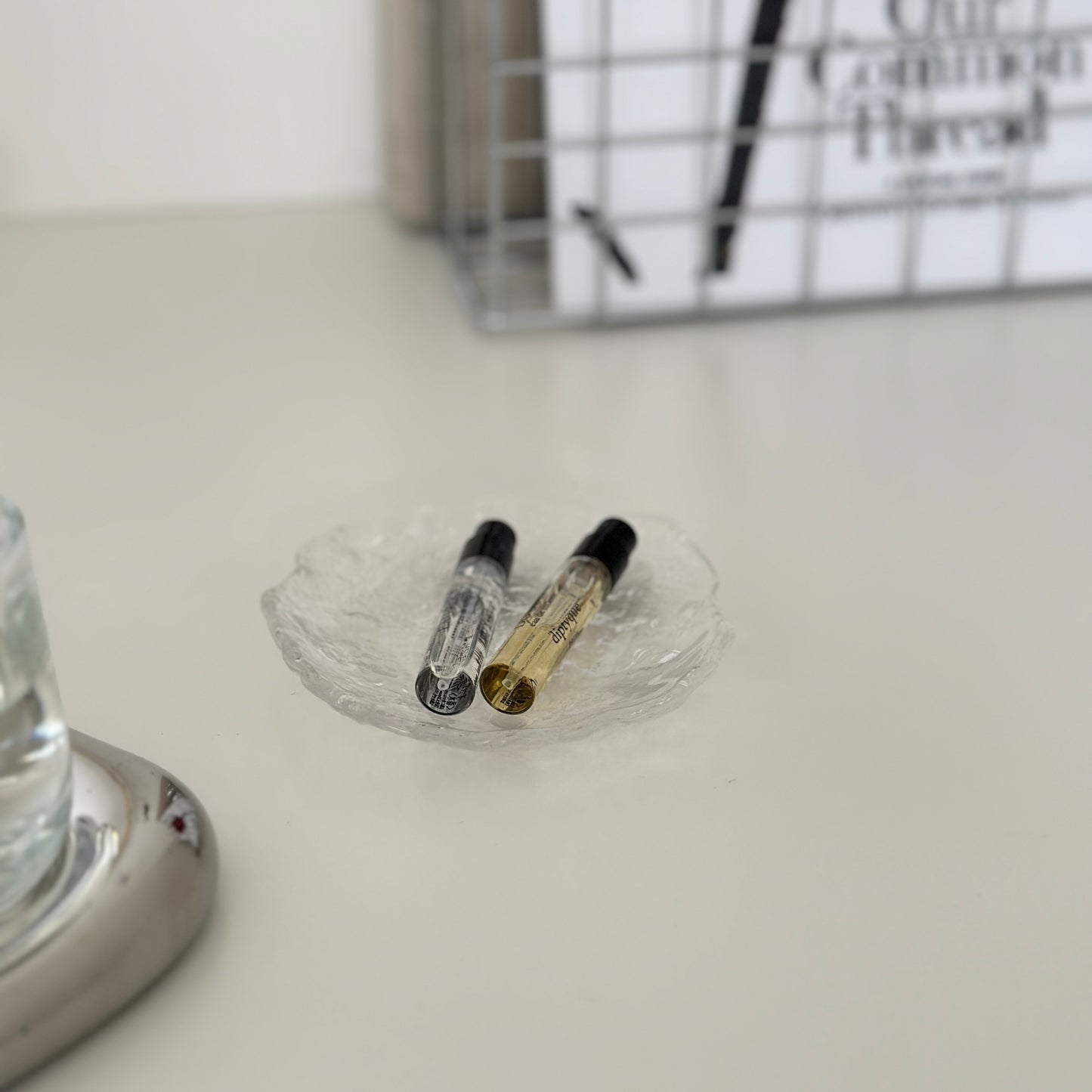 ガラスのプレートの上に香水が2つ乗っている