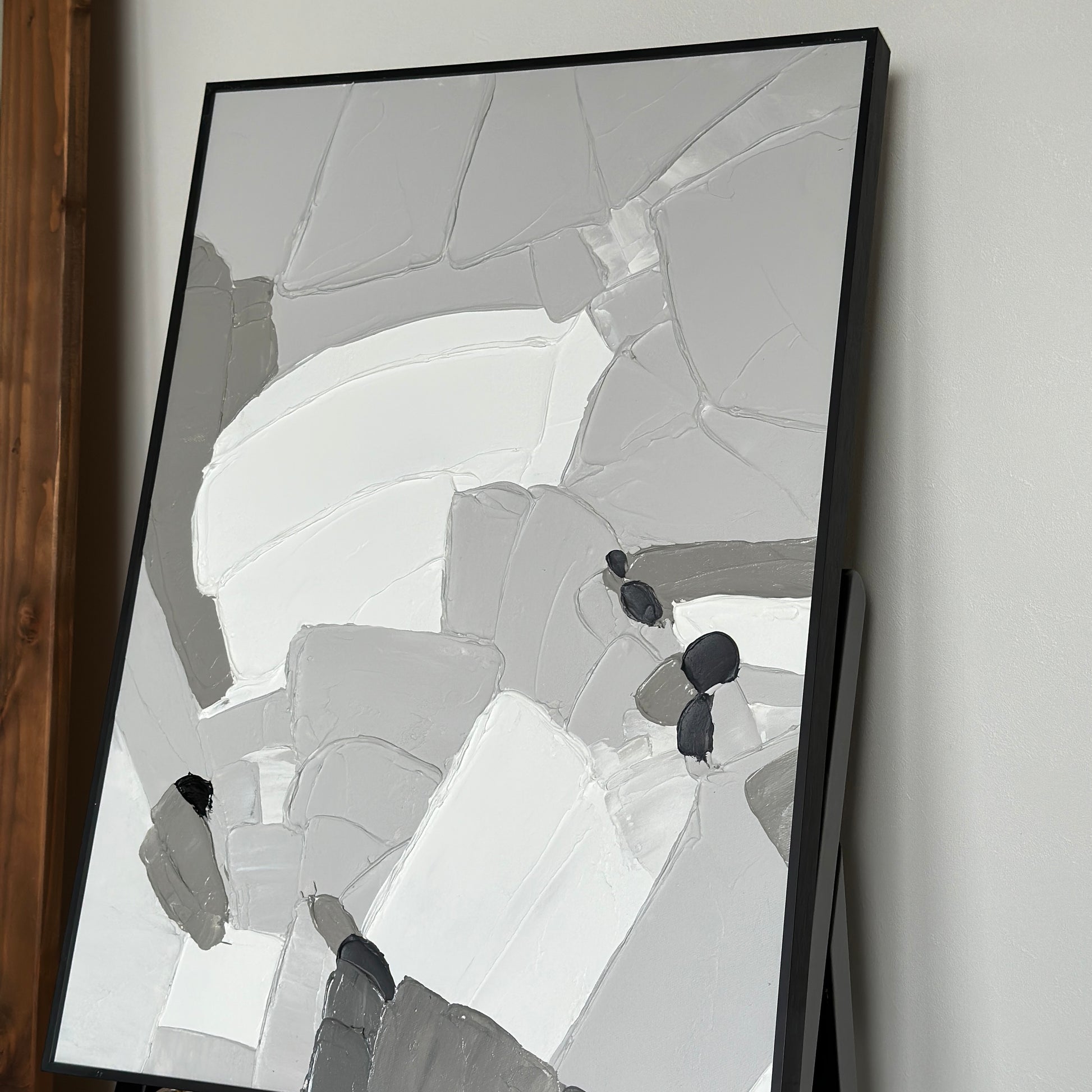 椅子の上に乗せられた表面に凹凸があるモノトーンカラーのアート