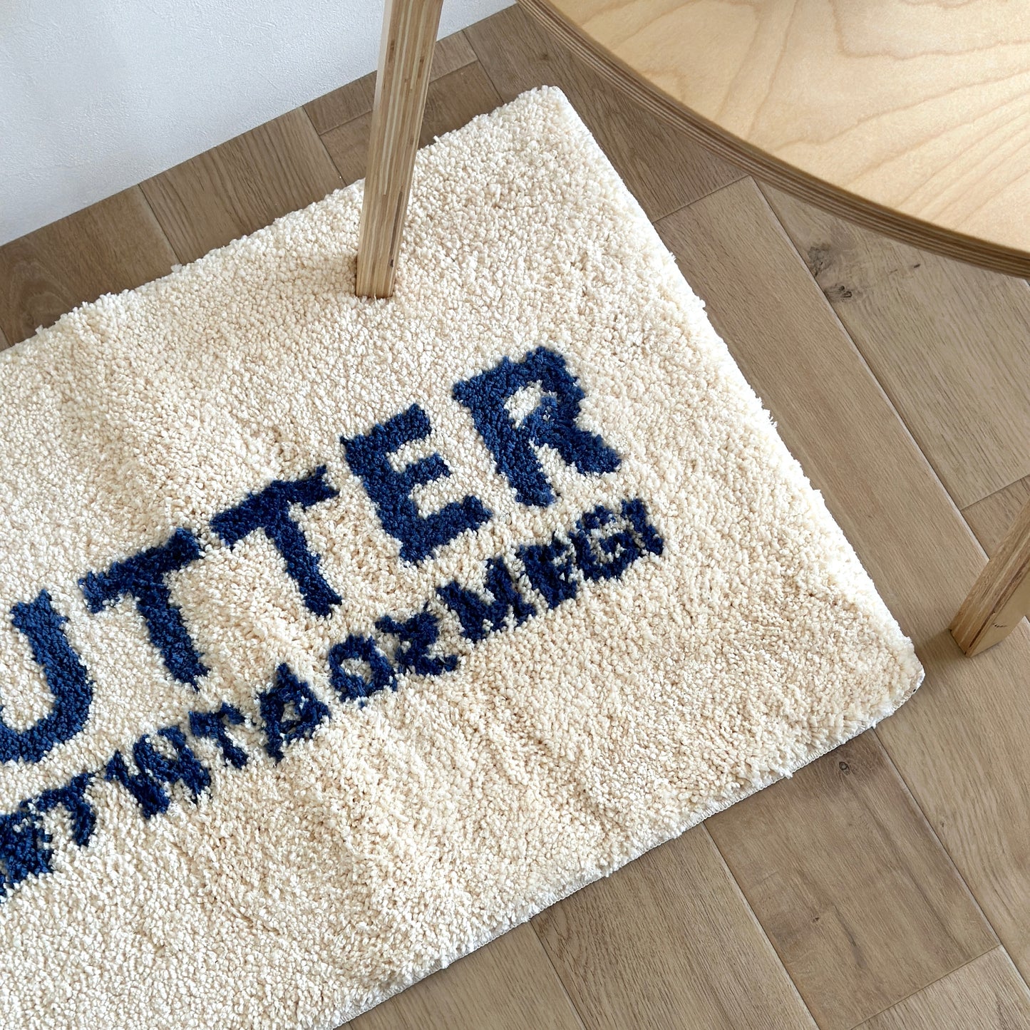 白地に青文字で”BUTTER”の文字が描かれたミニラグ