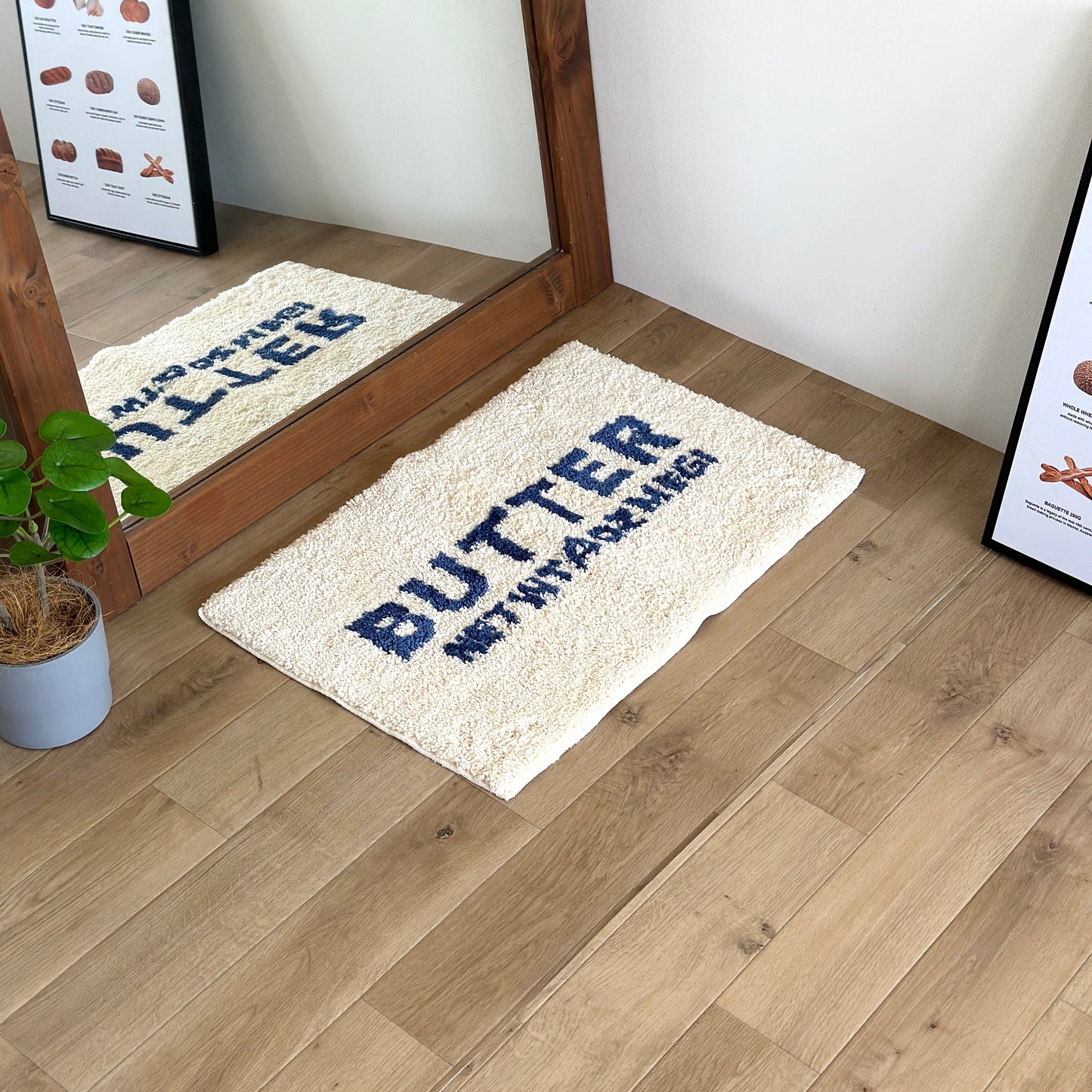 ミラーの前に置かれた白地に青文字で”BUTTER”の文字が描かれたミニラグ