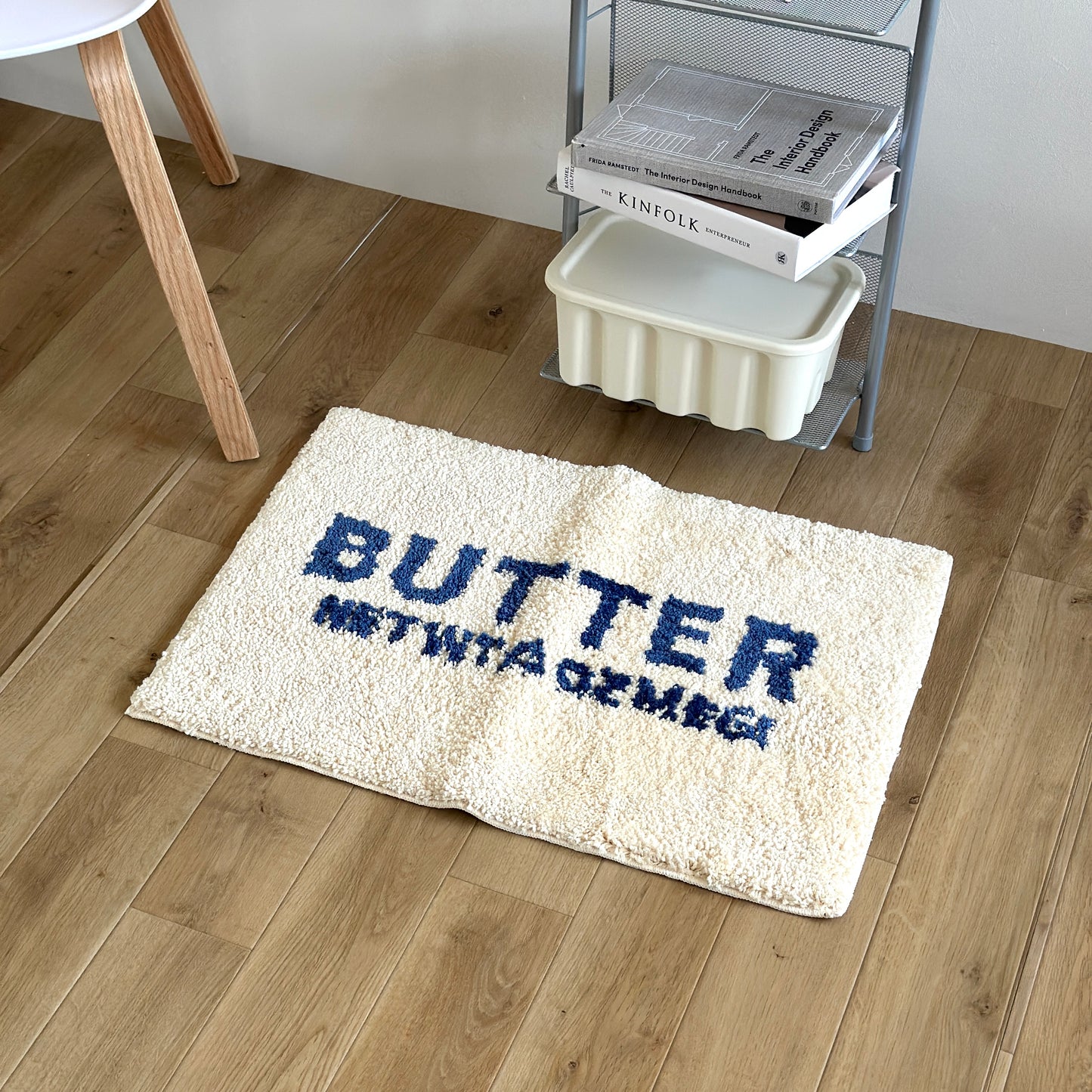 白地に青文字で”BUTTER”の文字が描かれたミニラグ