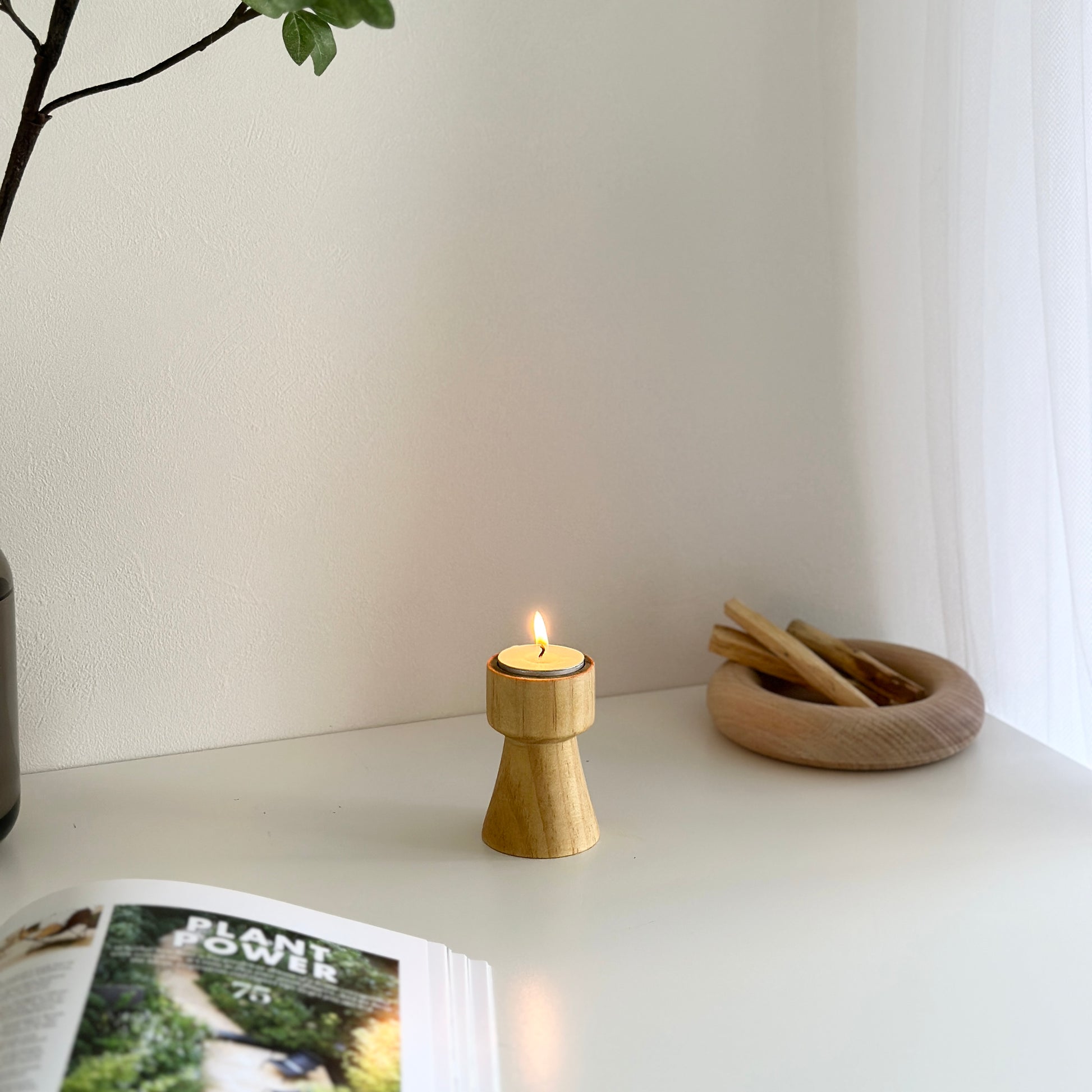 ウッドブラウンの木製のミニキャンドルホルダーと植物や木製のプレートが置いてある写真
