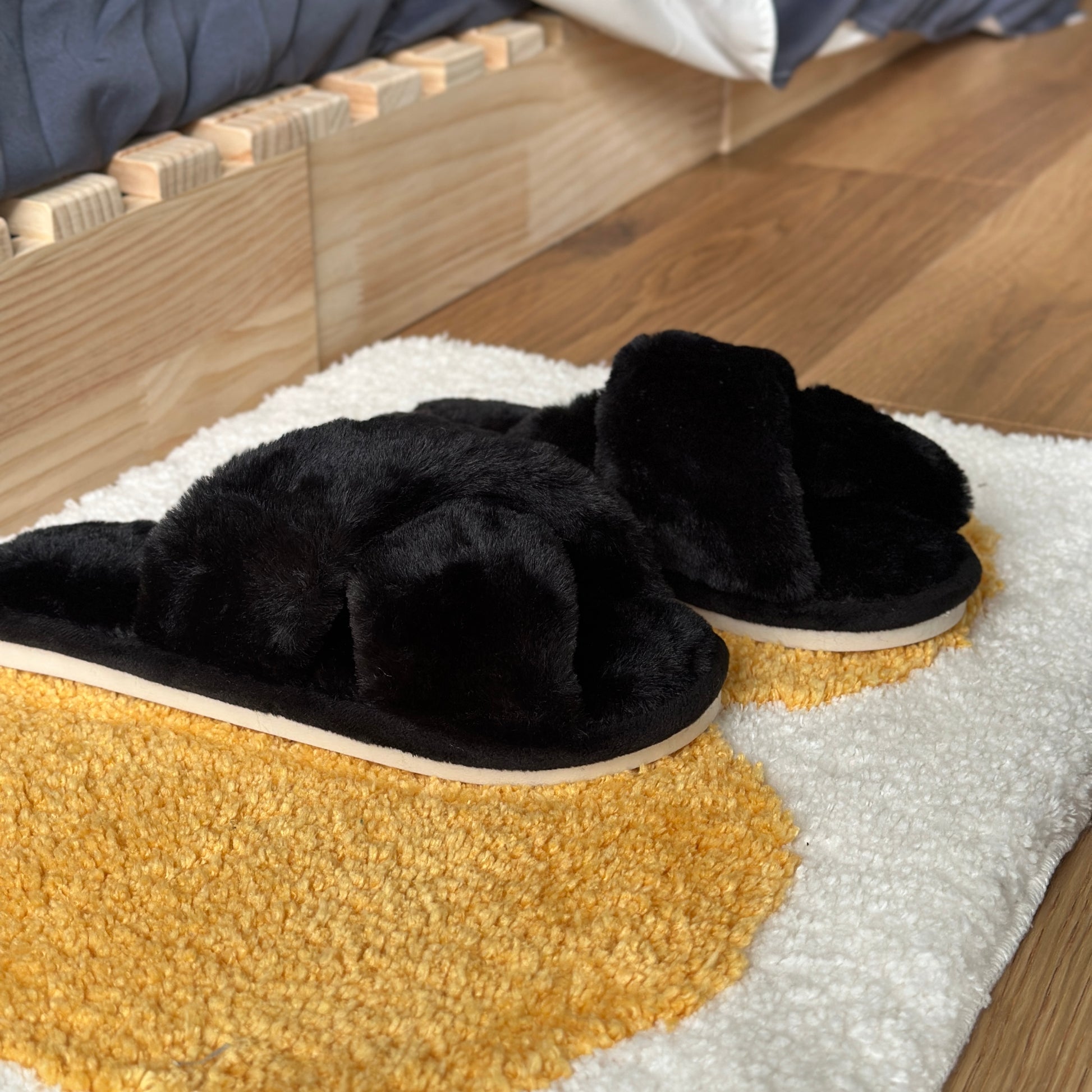 黒のファー素材のクロスされたスリッパ