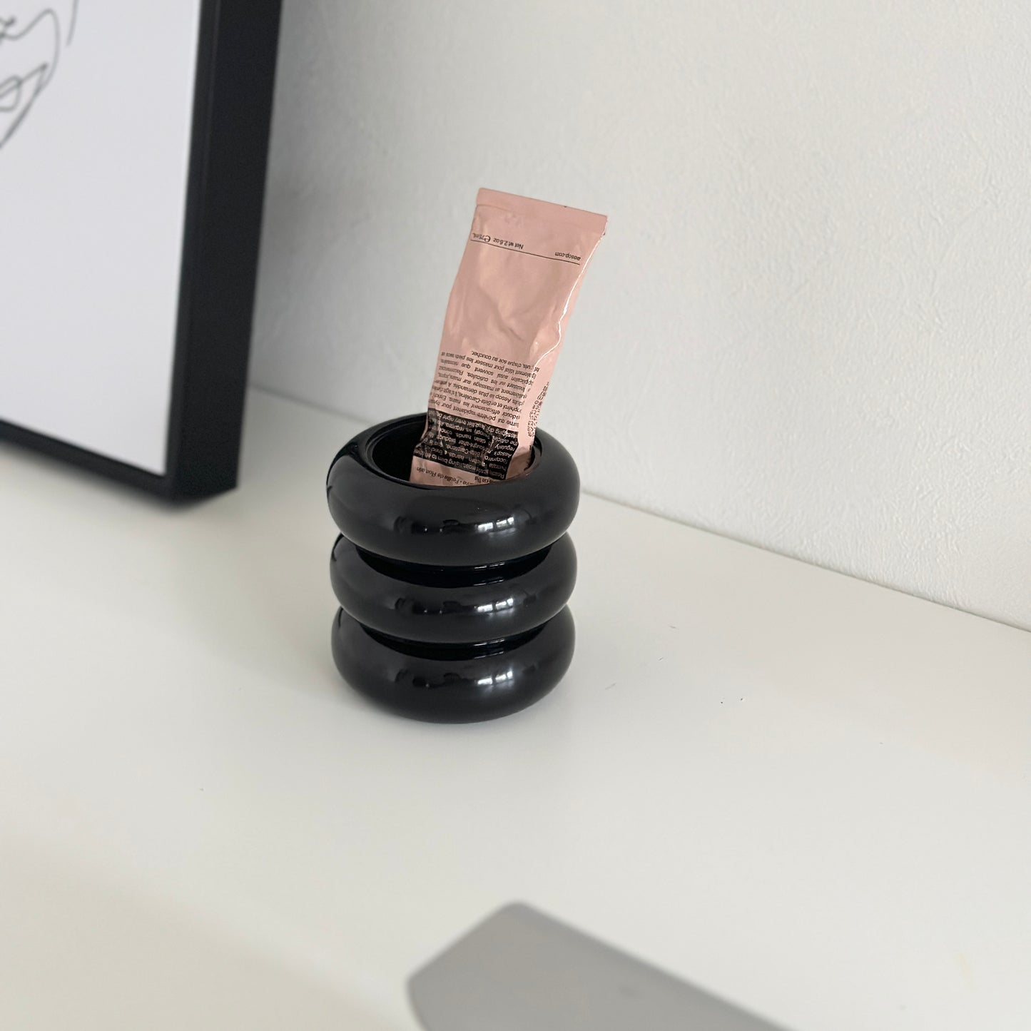 ブラックのぽってりとしたケースにハンドクリームが入れられている