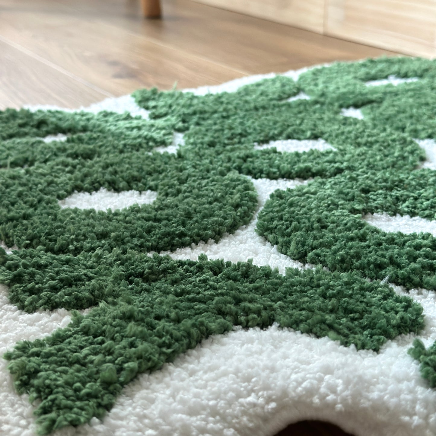 緑のレタリング文字が書かれた白のミニラグの表面