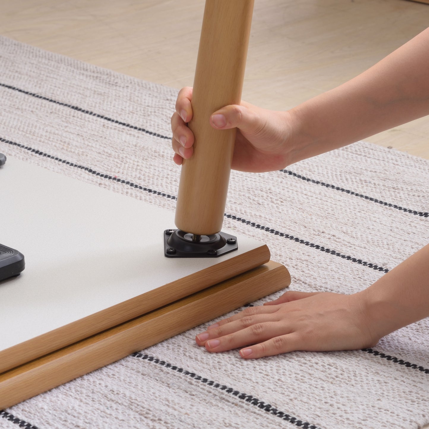 ナチュラルでシンプルなこたつテーブルの脚を取り付けている様子